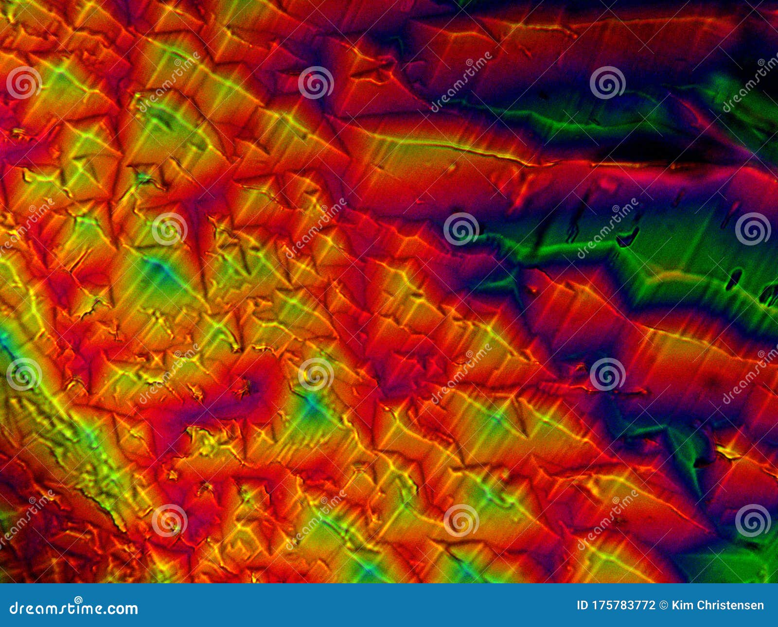 crystal layer on microscope object glass, seen in polarized light. this causes random unforeseeable color effects
