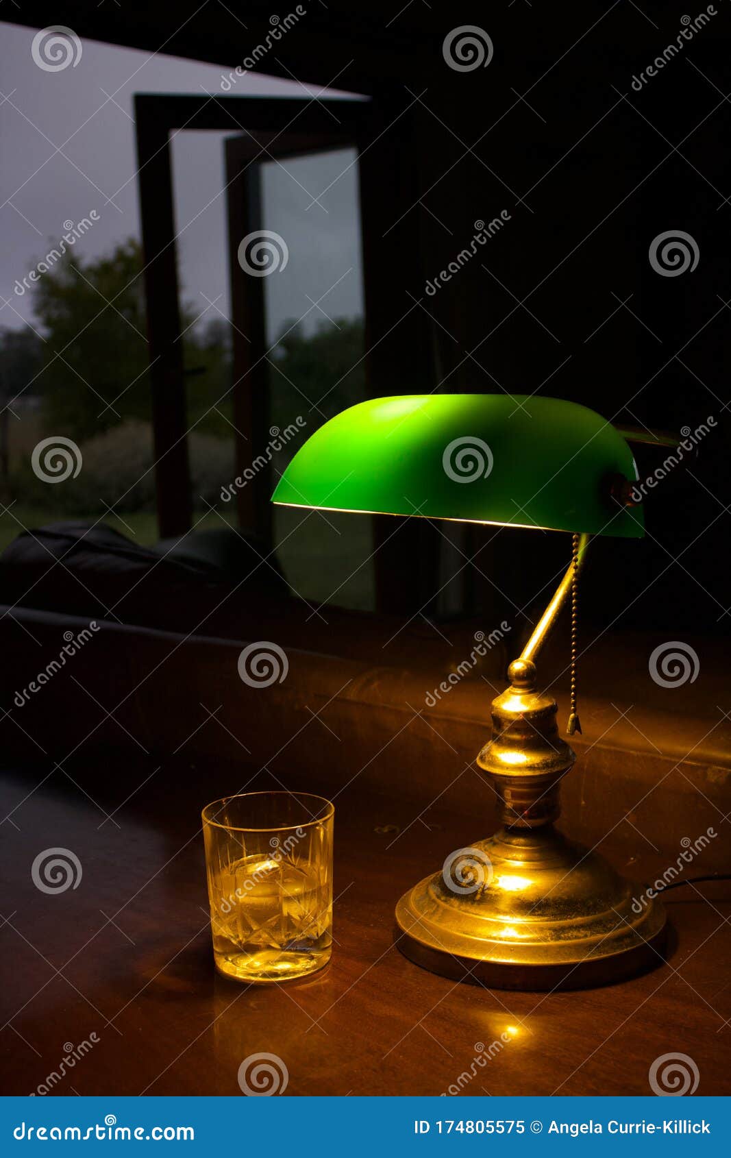 Crystal Whisky Glass Illuminated By A Green Study Desk Lamp Stock