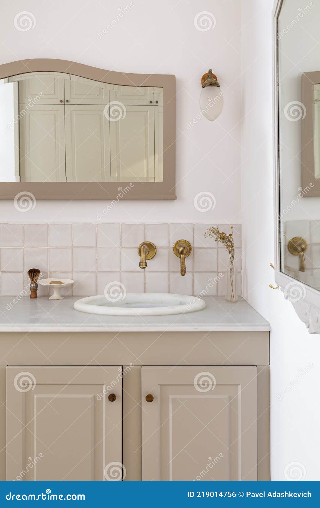 Un baño con lavabo blanco y grifo dorado.