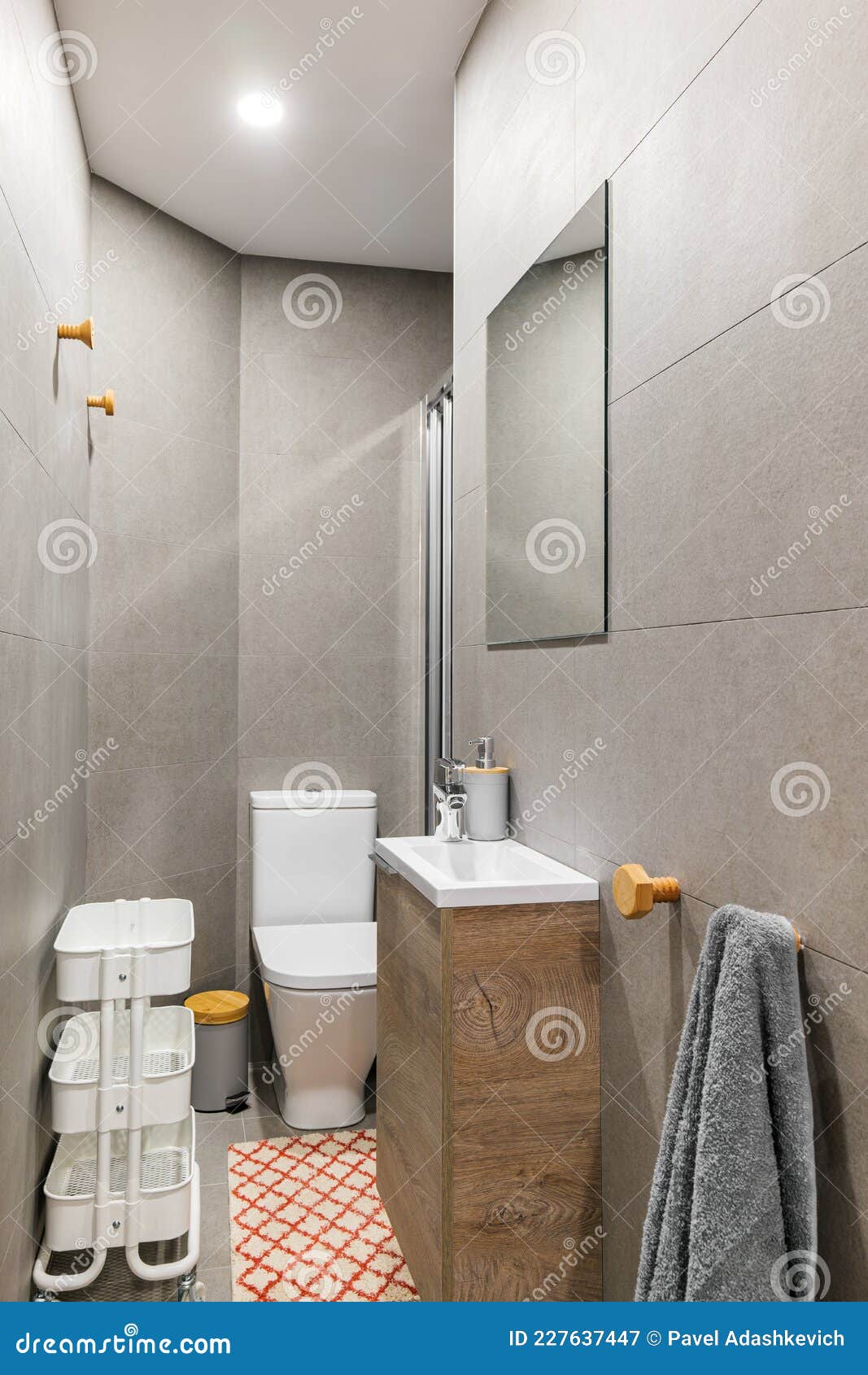 Baño estrecho con, aseo, lavabo pequeño, decorado con azulejos grises.  Interior de estilo contemporáneo después de la renovación del hogar  Fotografía de stock - Alamy