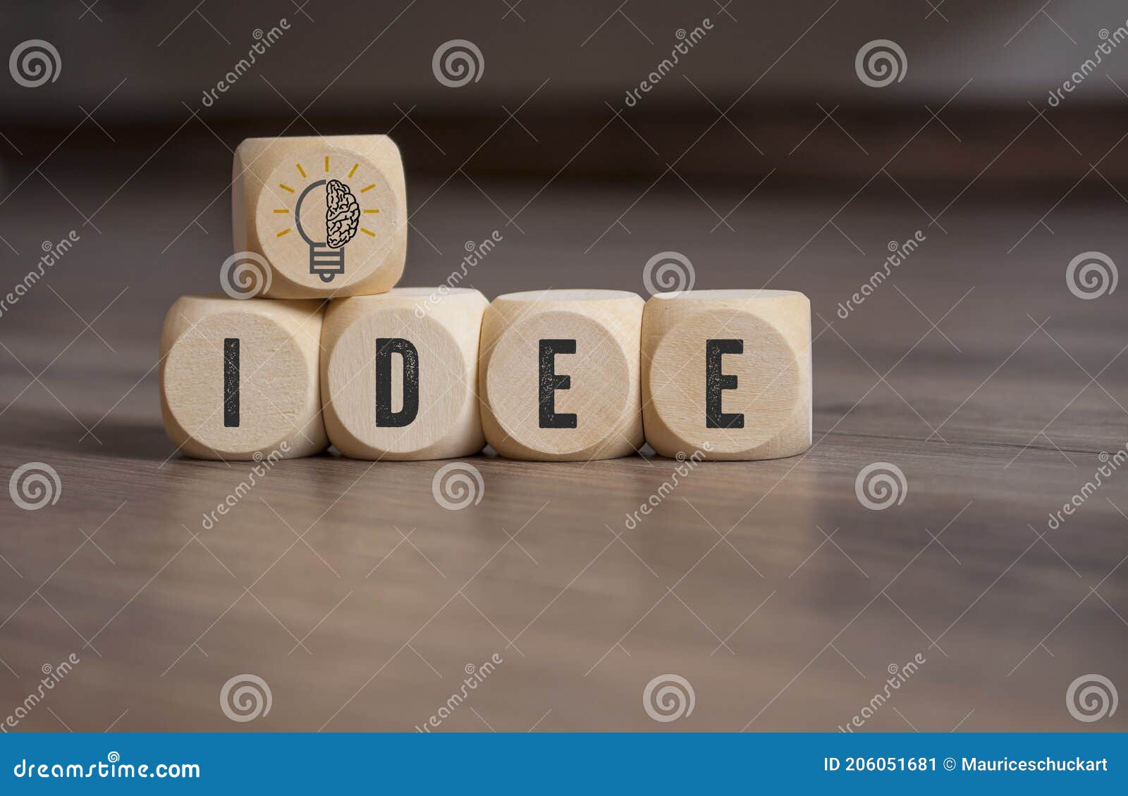 cubes, dice and blocks with a brain and light bulb showing the word idea and idee on wooden background
