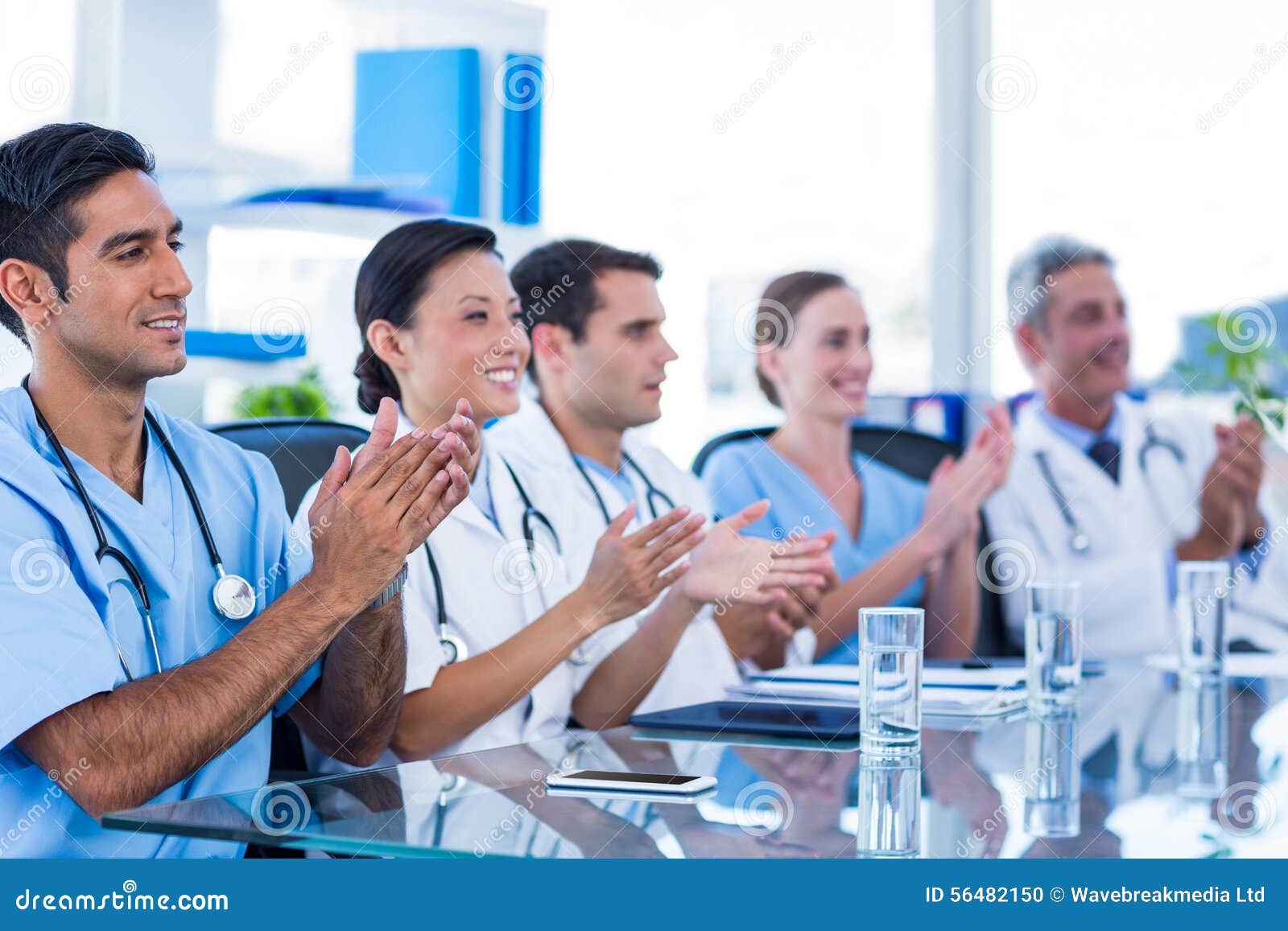 Cuida el aplauso mientras que se sienta en una tabla en oficina médica
