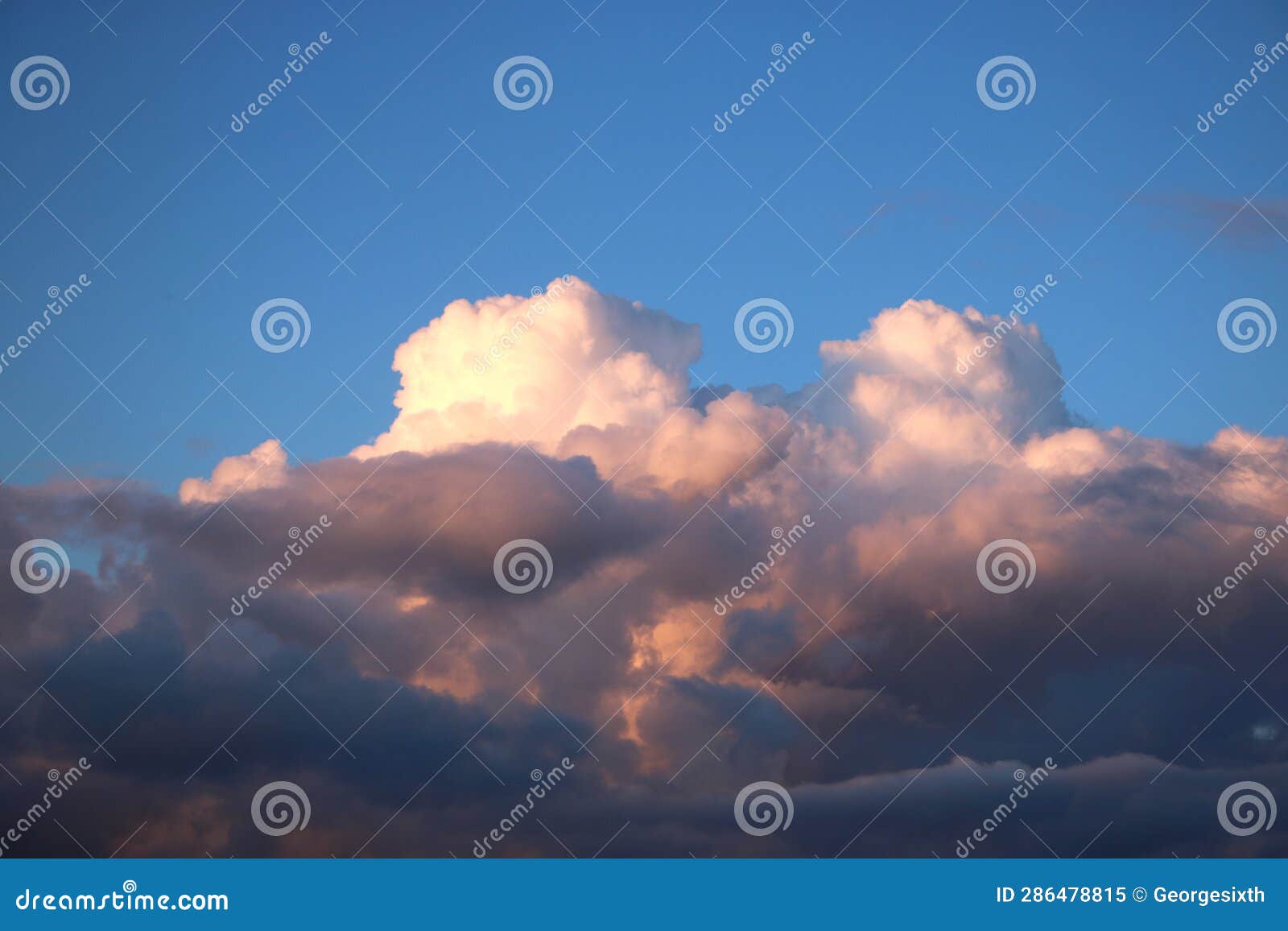 cumulo-nimbus clouds pink at sunset and blue sky