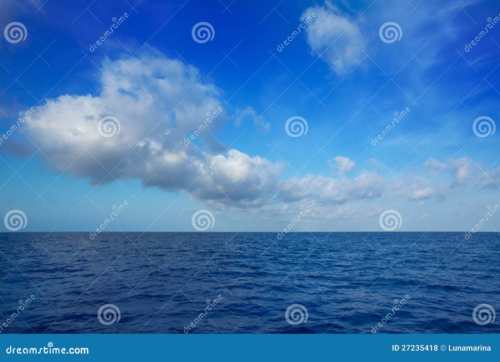 cumulus clouds in blue sky over water horizon