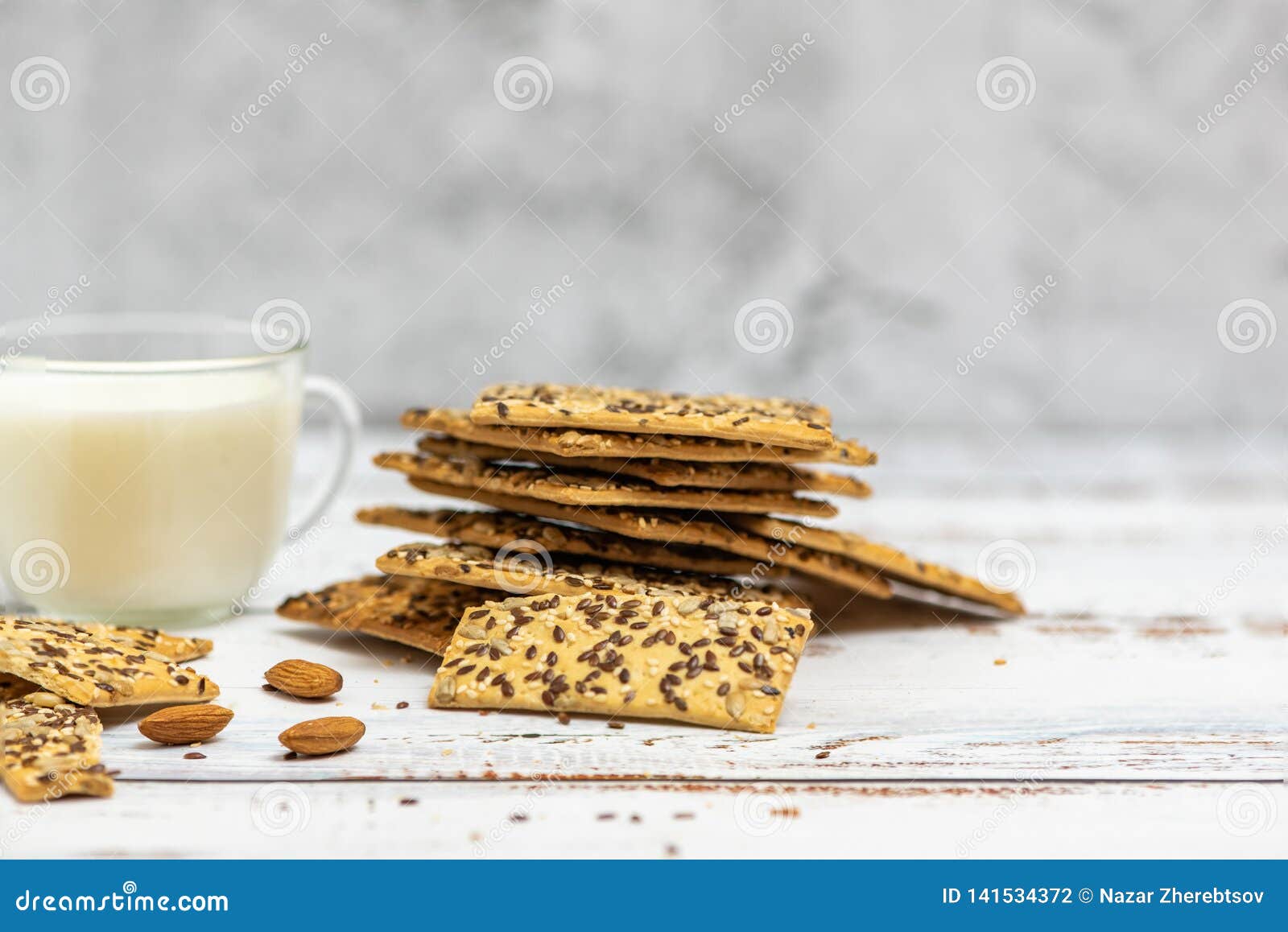 cup of almond milk and stack of whole grain biscuits on light background. with copy space