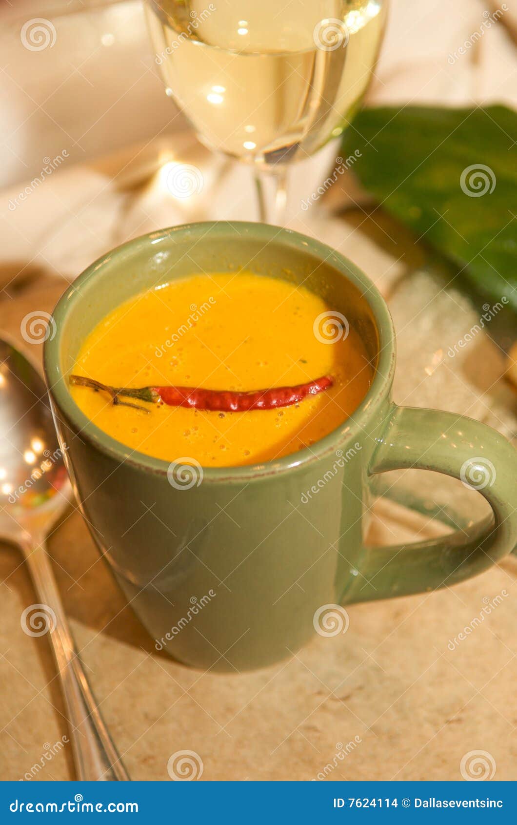 cup of cheese queso with a chili garnish