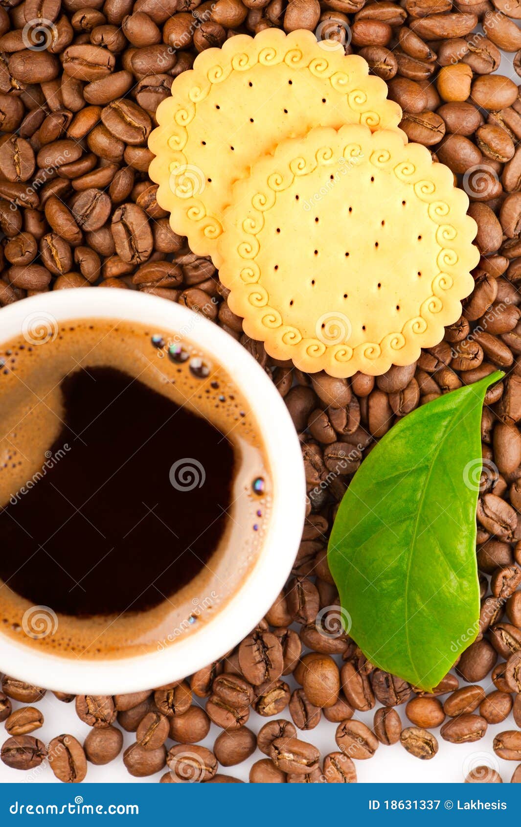Coffee beans, green leaf of coffee plant with cookies and cup of coffee. Focus on beans