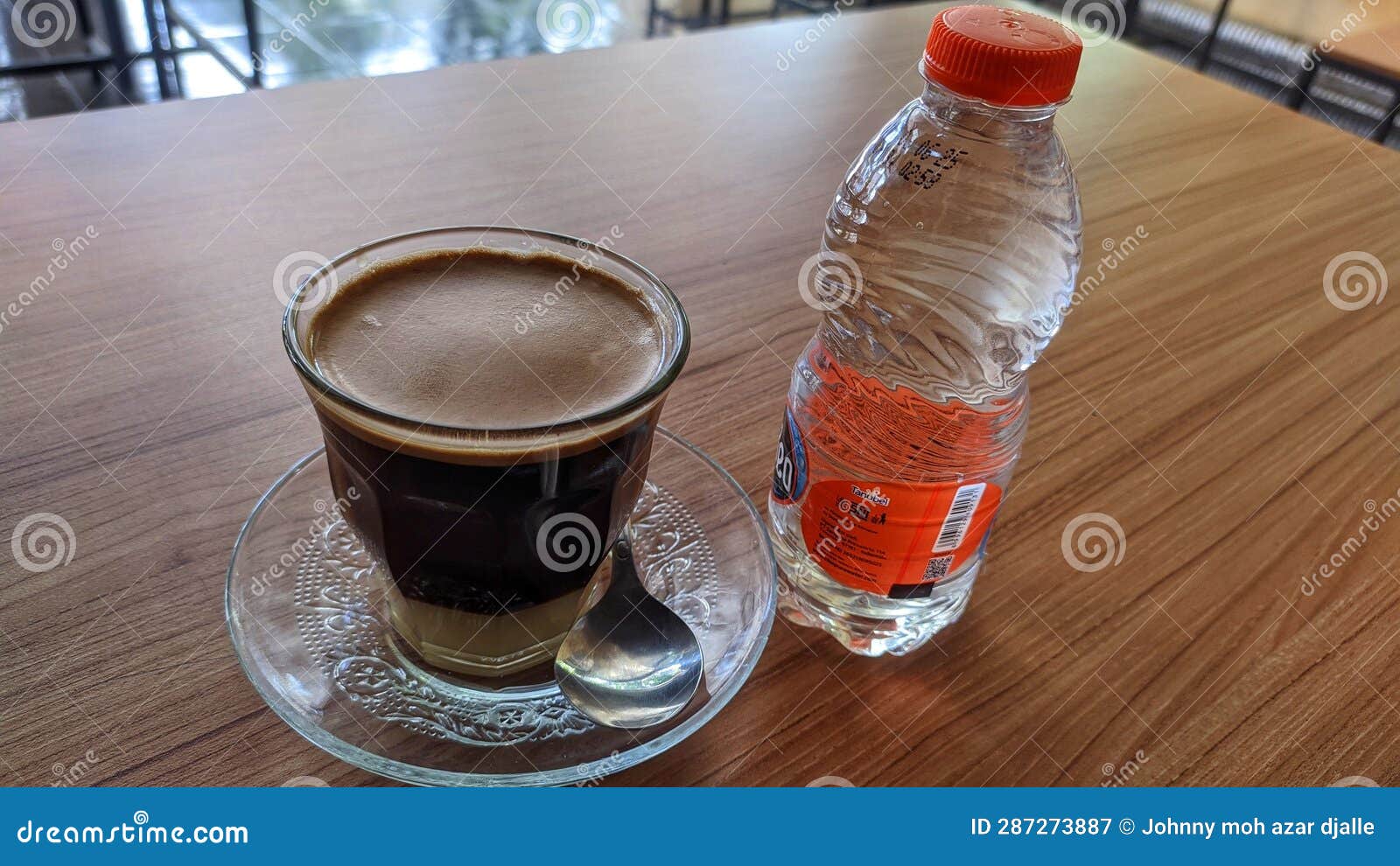 A Cup of Coffee and a Bottled Mineral Water on the Wooden Table Stock