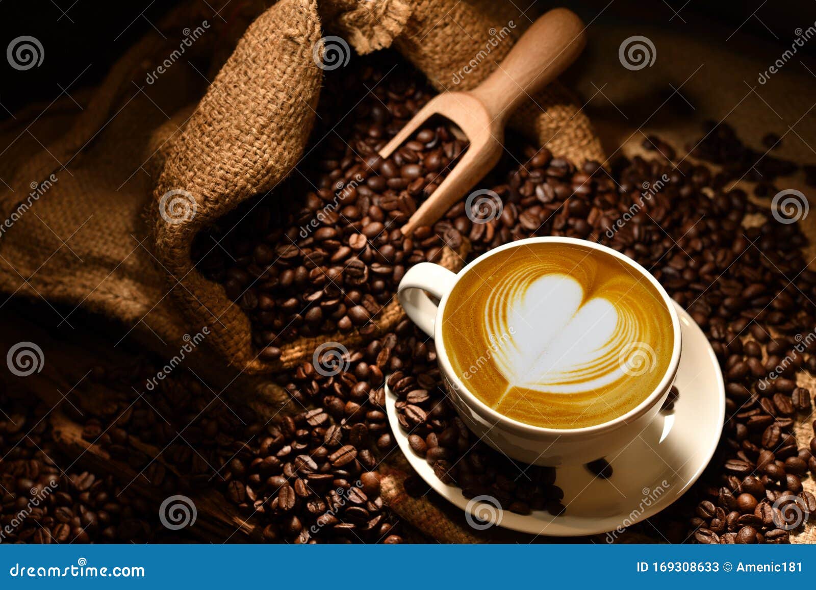 cup of coffee latte with heart  and coffee beans on old wooden background