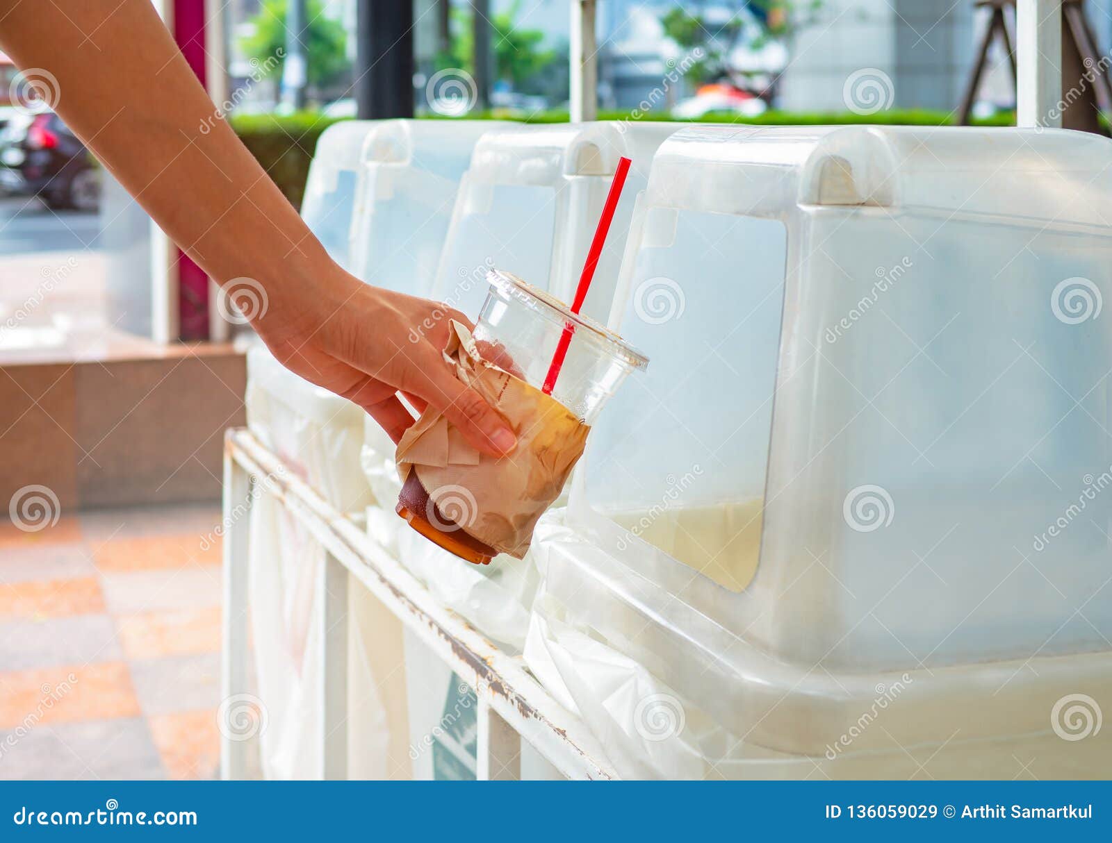 Hand Throwing Empty Plastic Coffee Cup into the Recycling Bin Stock
