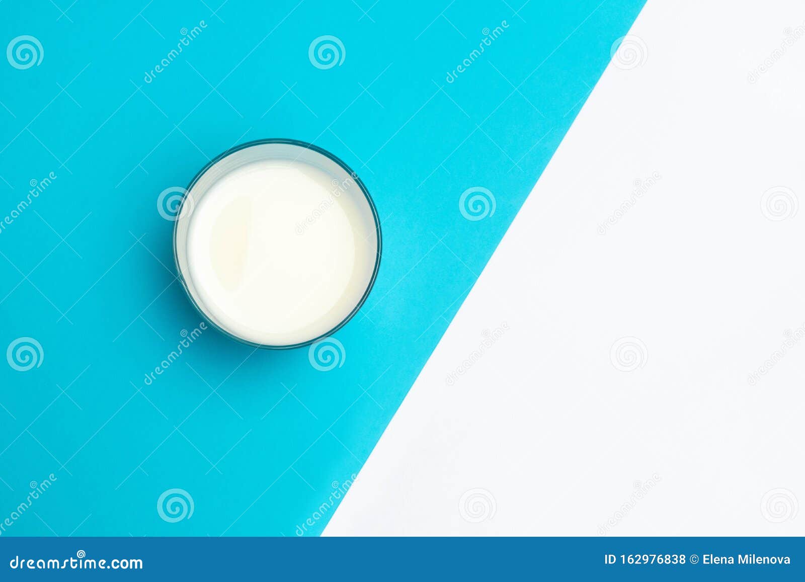 cup of fermented drink ayran kefir on blue and white geometric background