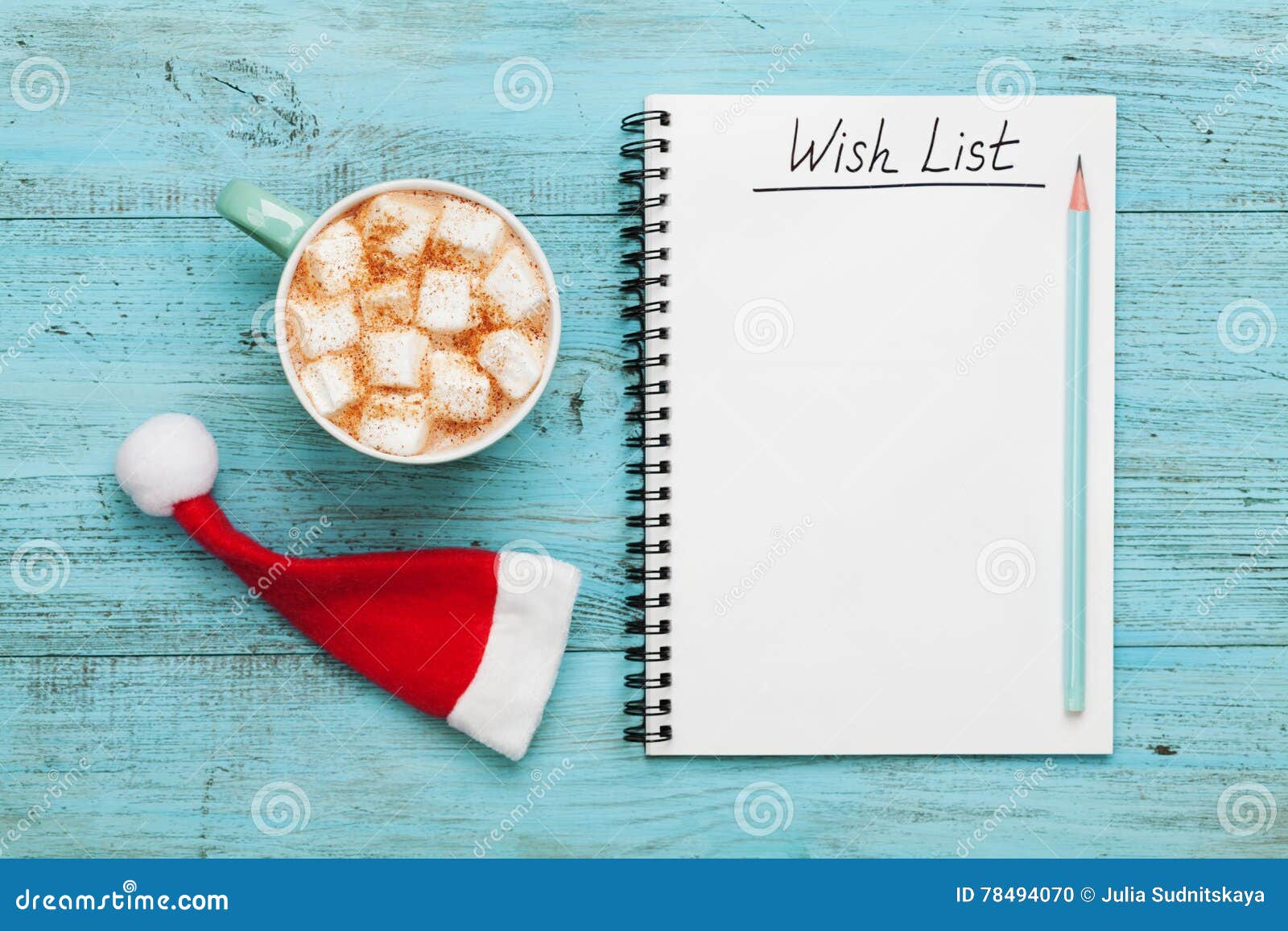 cup of hot cocoa or chocolate with marshmallow, santa claus hat and notebook with wish list, christmas planning concept. flat