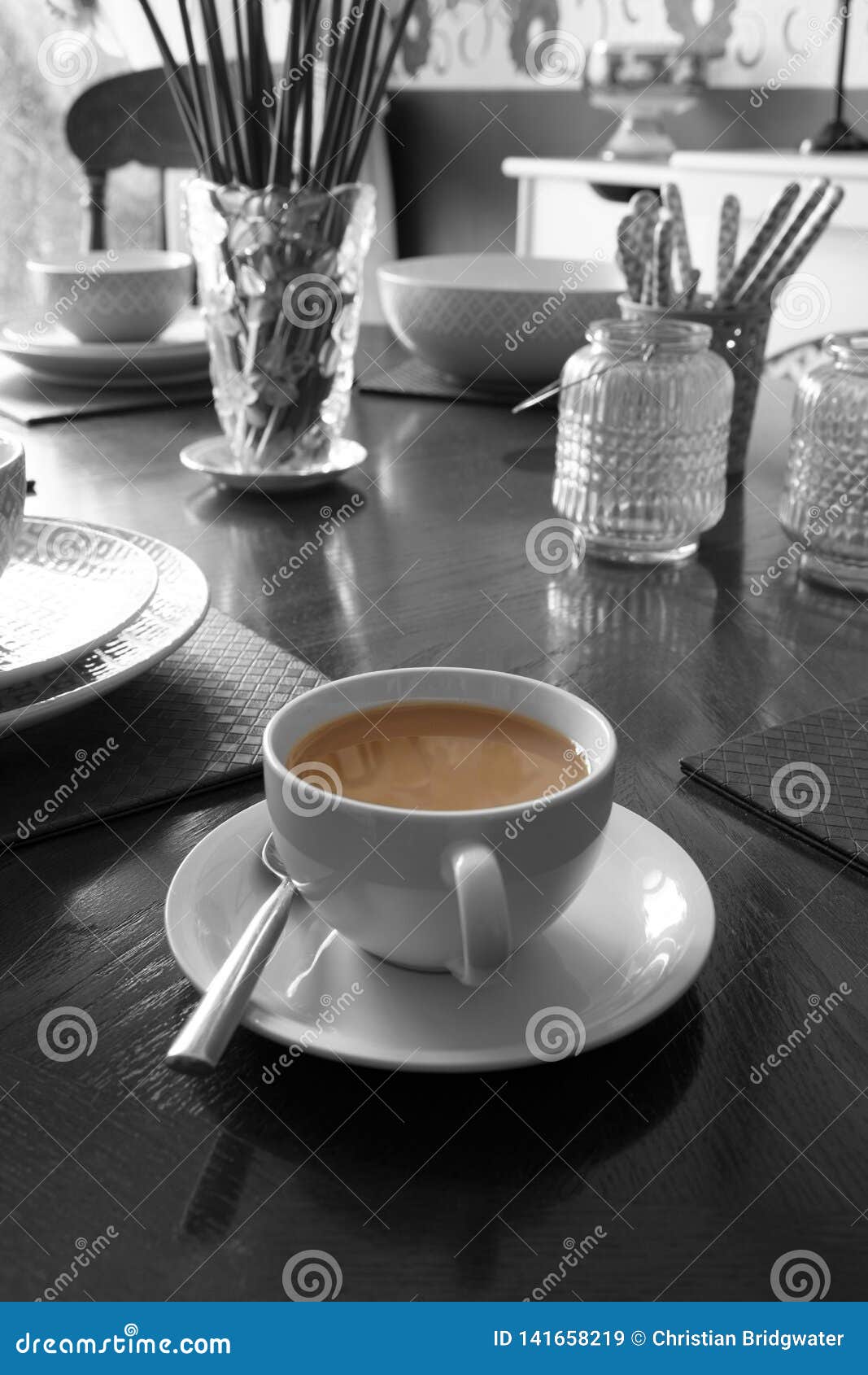 Cup of Tea on a Dining Table with Dinner Setting and Ornaments Stock