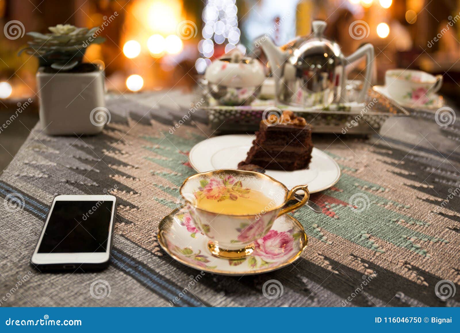 Cup Of Tea And Slice Of Chocolate And Tea Pot With Bokeh Light Stock