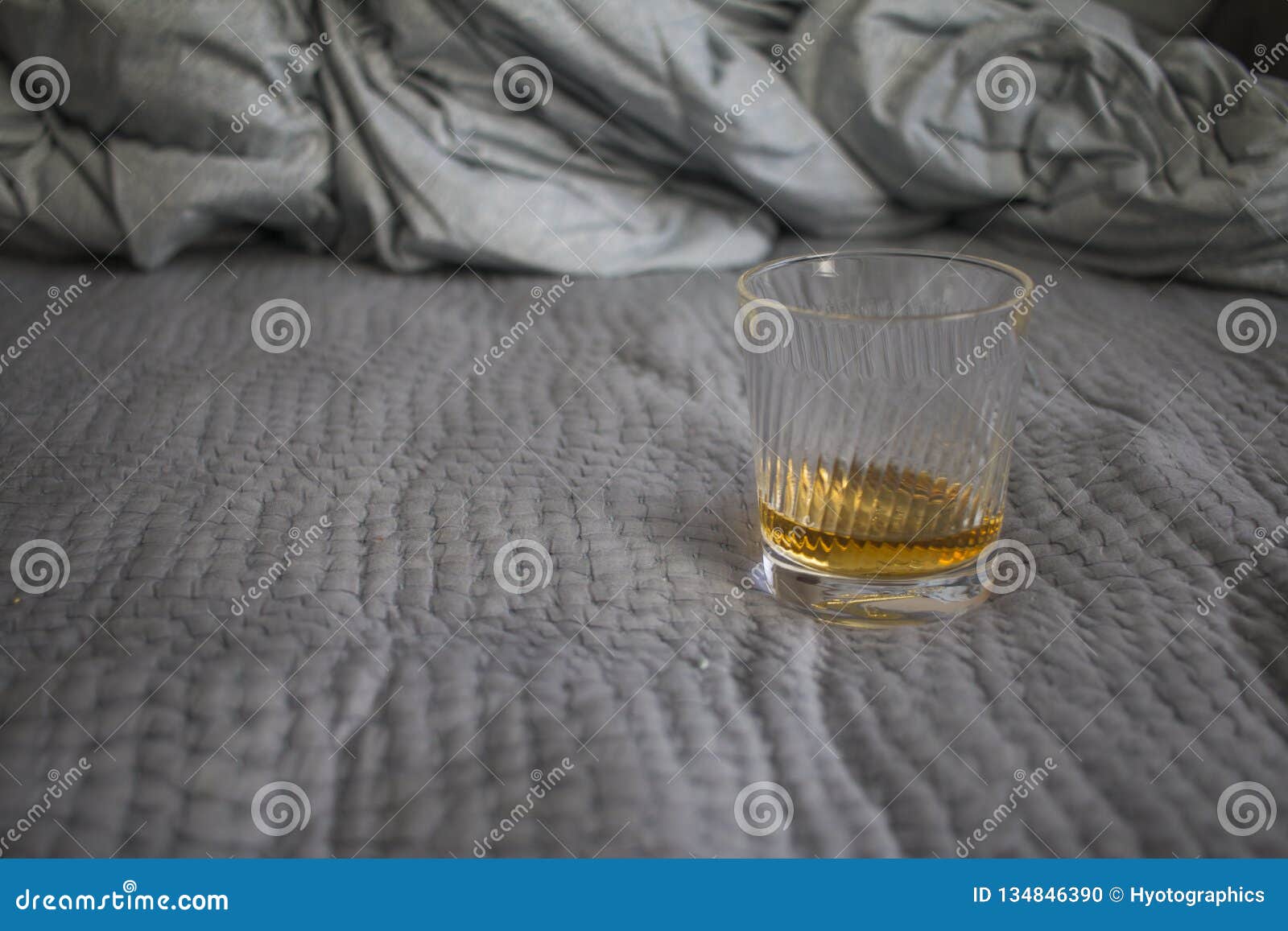 A cup of whisky on the bed stock photo. Image of alcohol 134846390