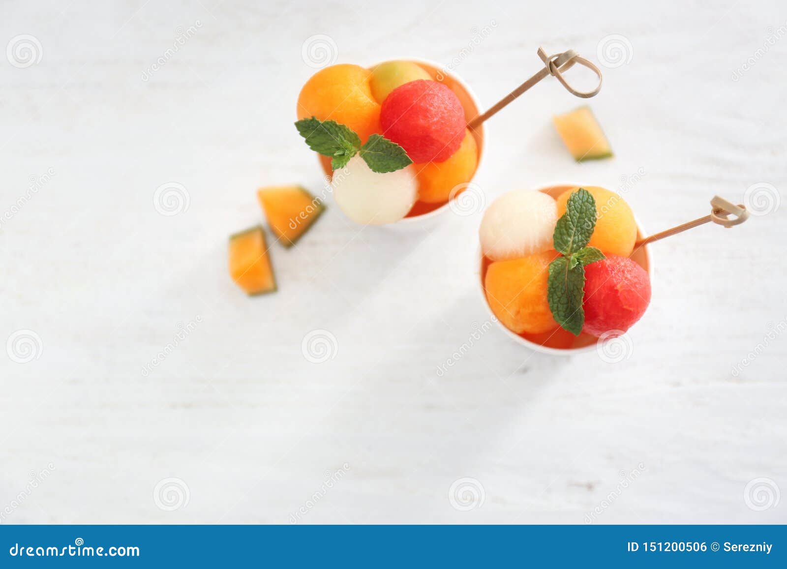 Cups with Fresh Melon and Watermelon Balls on Light Table Stock Photo