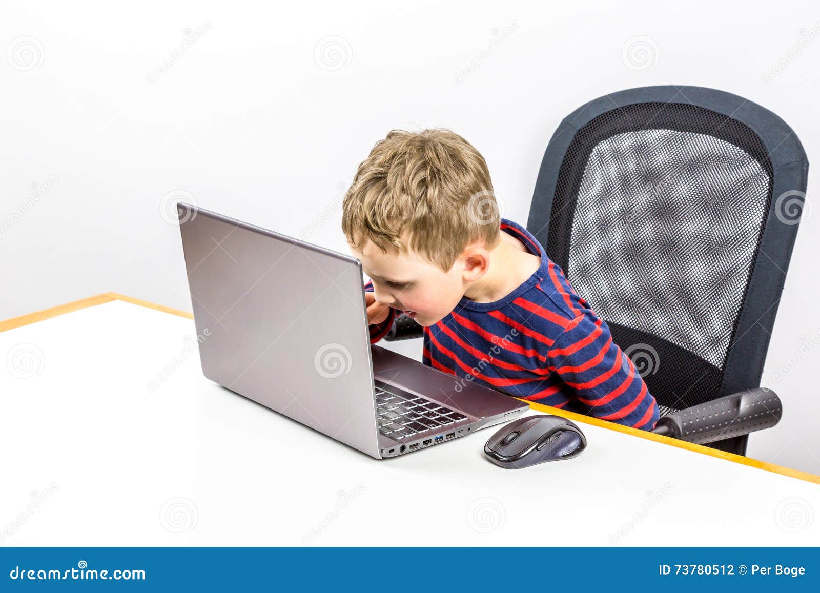 curious caucasian preschool boy using laptop, studio shot.