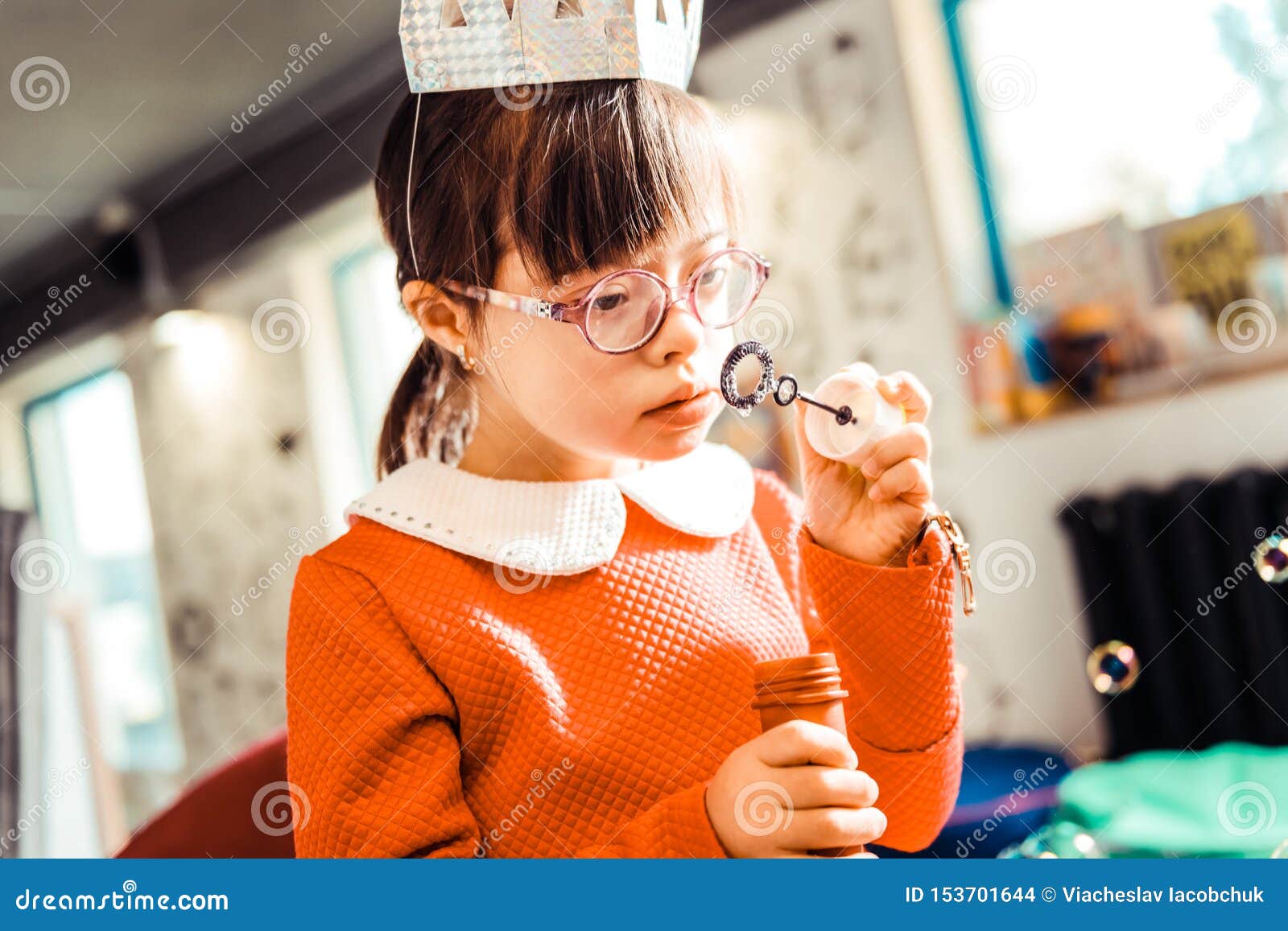 Curious Darkhaired Girl Smelling Liquid for Soapy Bubbles Stock Photo