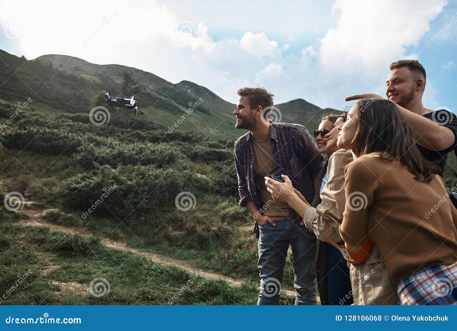 curious friends smiling and looking at the flying dron