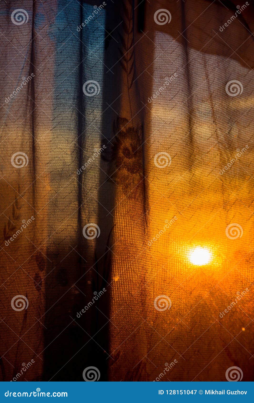 through the curtain shines the setting sun