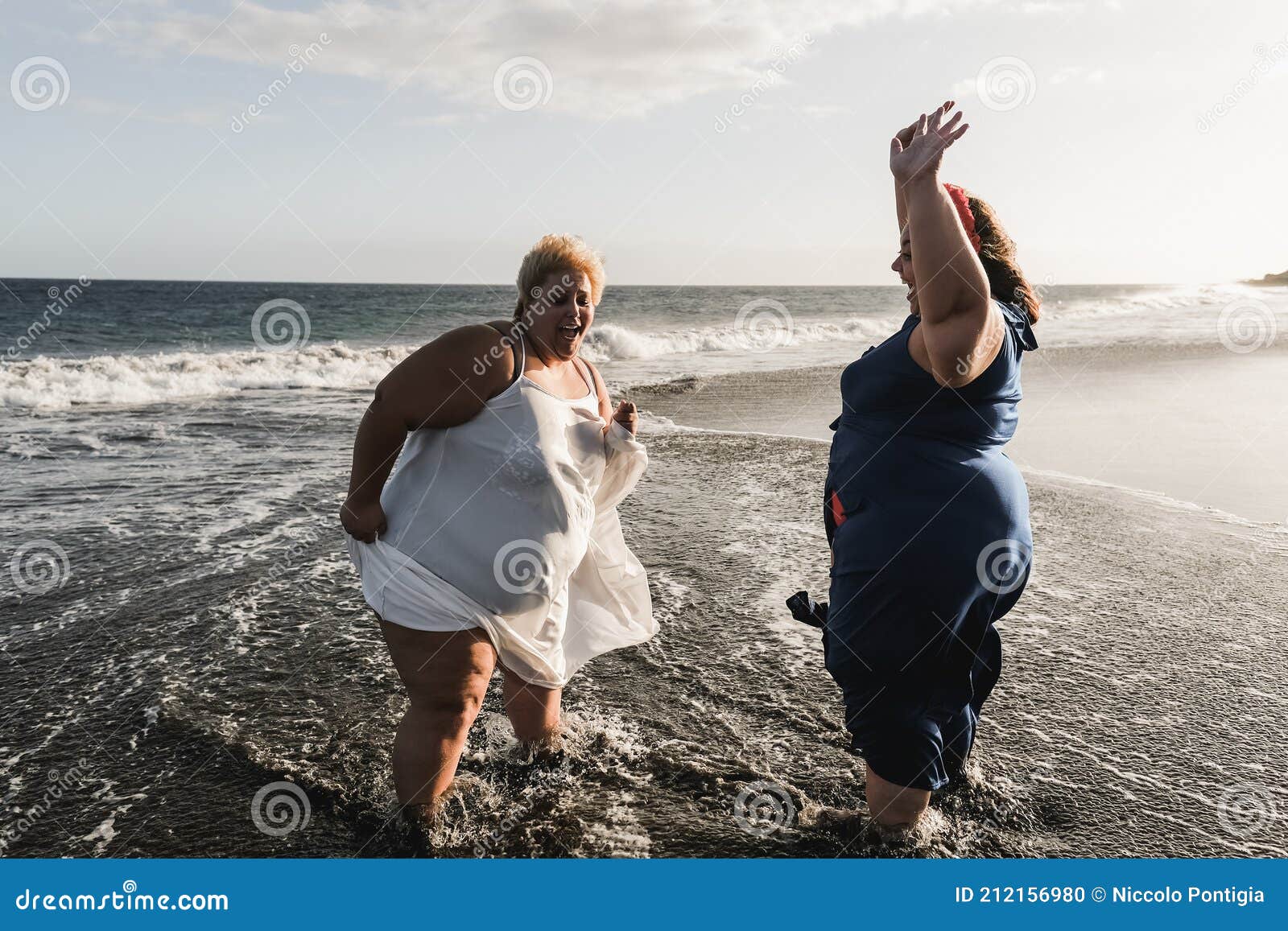 Curvy Women Dancing On The Beach Having Fun During Summer Vacation Focus On Left Woman Stock