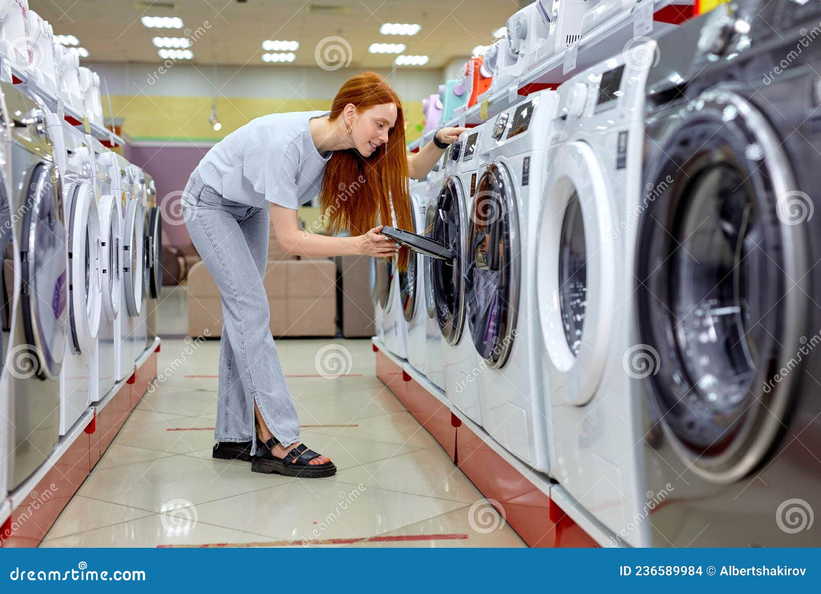 customer buying new clothes washer in supermarket, choosing the best and the most modern