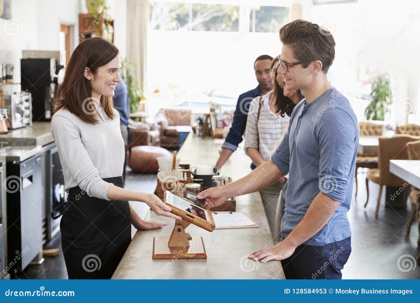 Customer at the Front of the Queue Paying in a Coffee Shop Stock Image