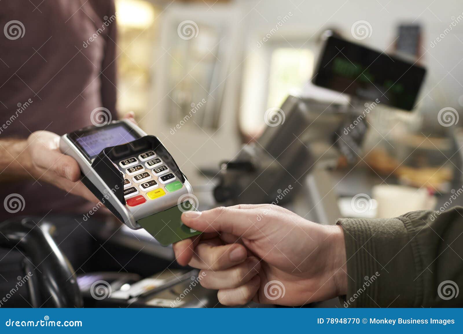 customer makes credit card payment over counter at a cafe