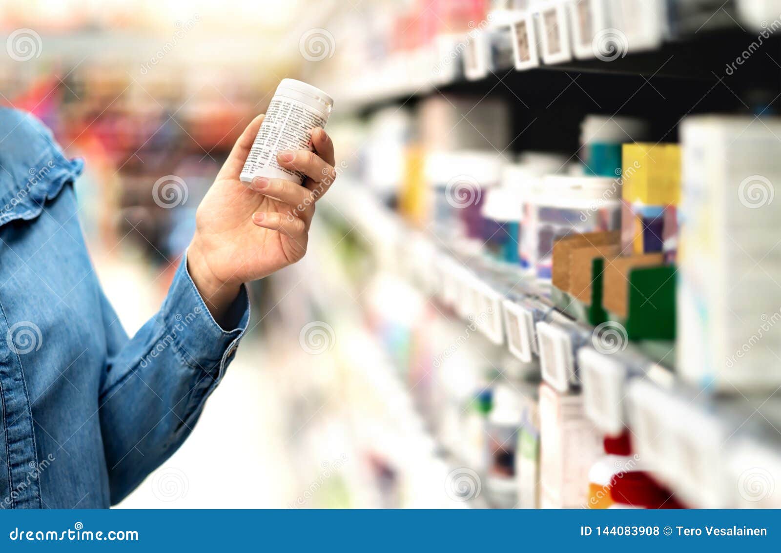 customer in pharmacy holding medicine bottle. woman reading the label text about medical information or side effects in drug store