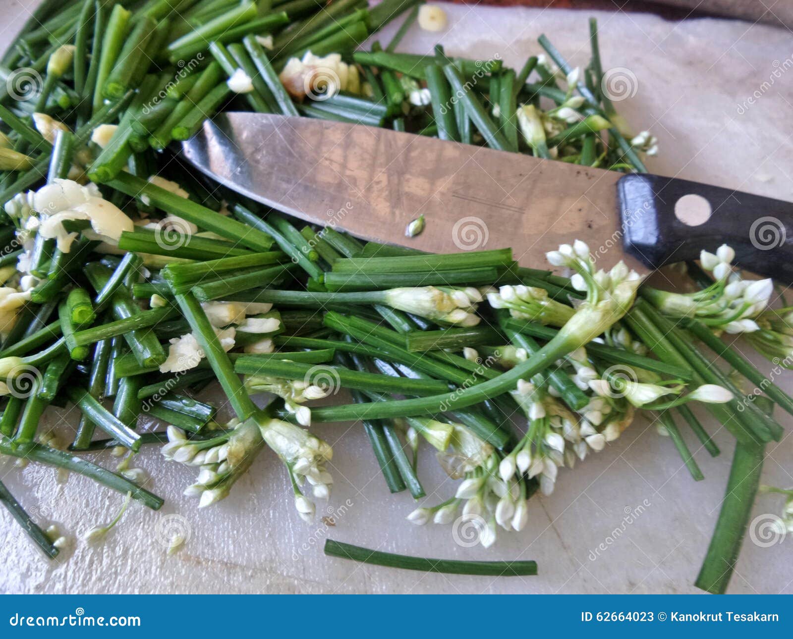 Cut Garlic Chives and Knives on Cutting Board in the Kitchen Stock
