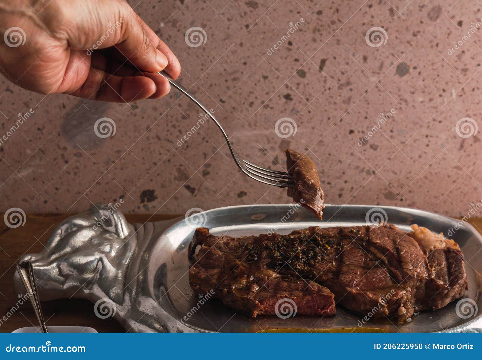 cut of meat `aguja norteÃÂ±a sonora`, served on a silver plate in the  of a cow 10