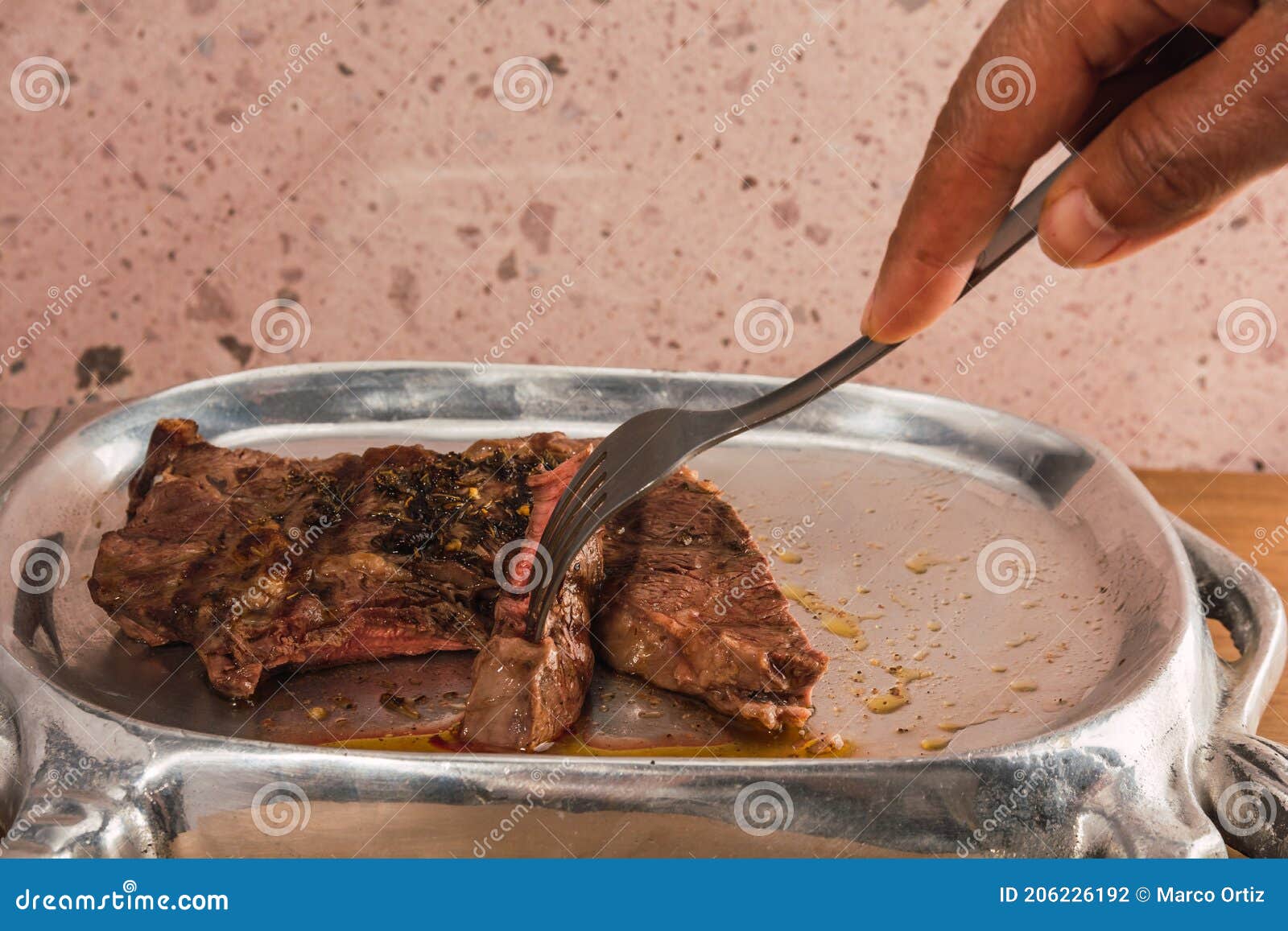 cut of meat `aguja norteÃÂ±a sonora`, served on a silver plate in the  of a cow