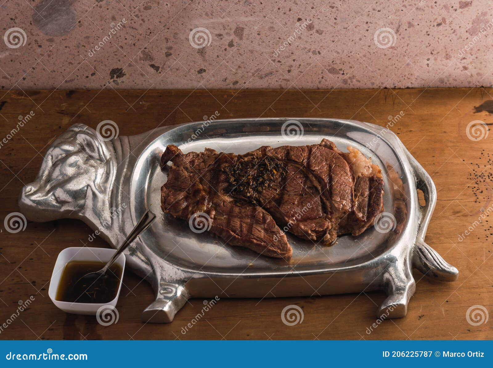 cut of meat `aguja norteÃÂ±a sonora`, served on a silver plate in the  of a cow 16