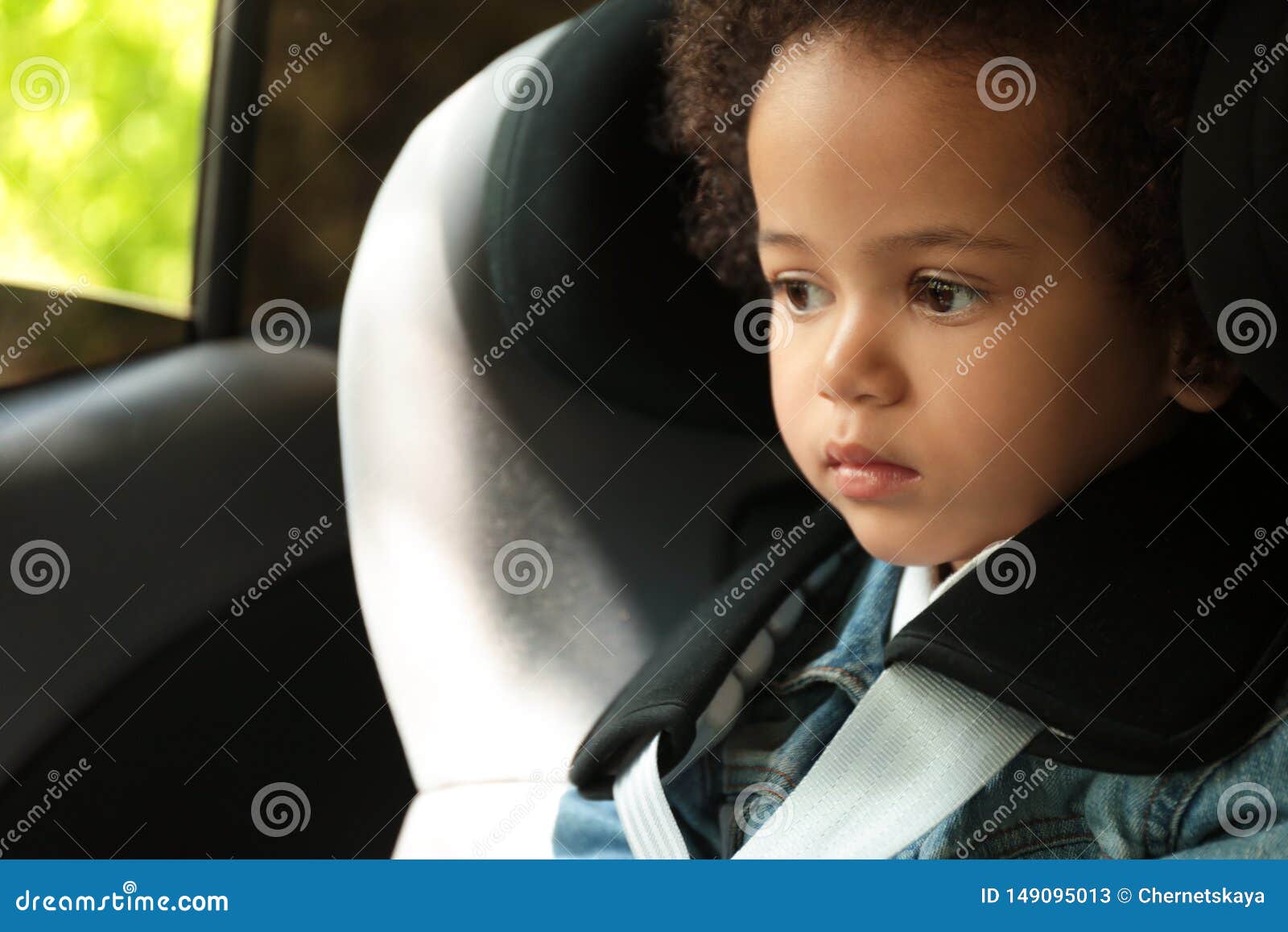 Cute African-American Girl Sitting in Safety Seat Alone. Child in ...