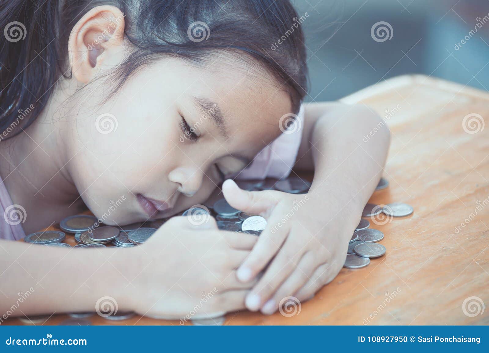 cute asian little child girl hugging and stingy her money