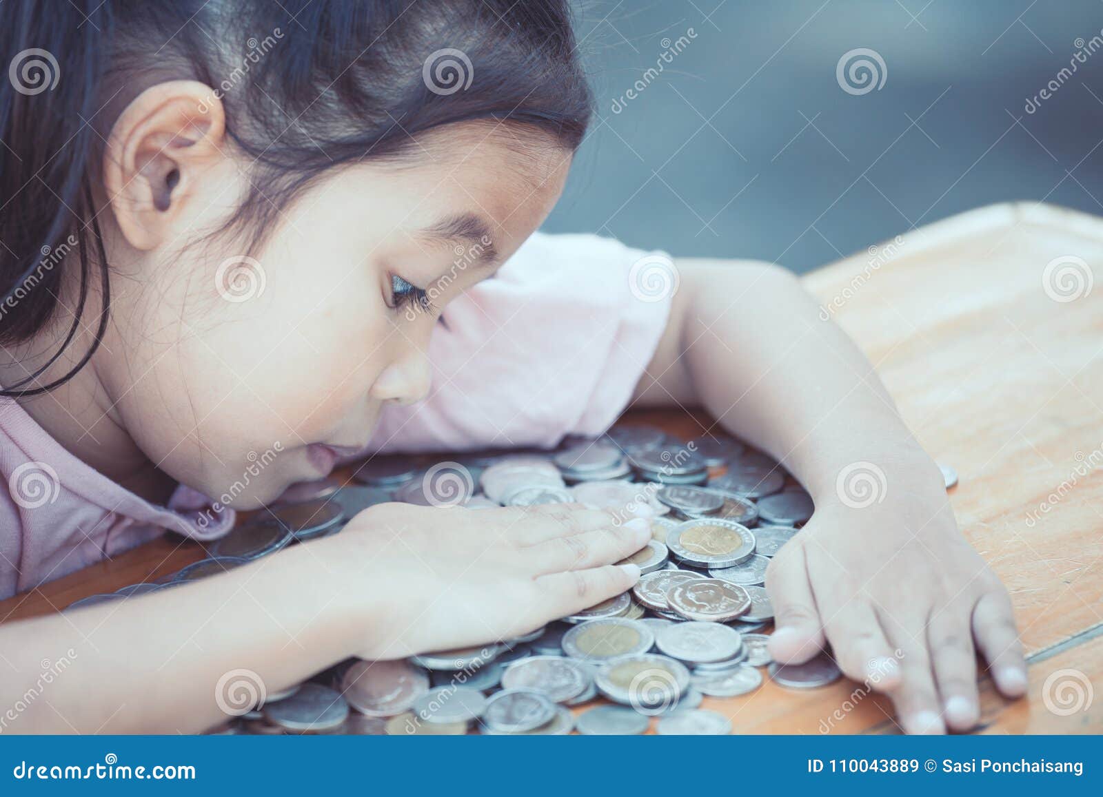 cute asian little child girl hugging and stingy her money