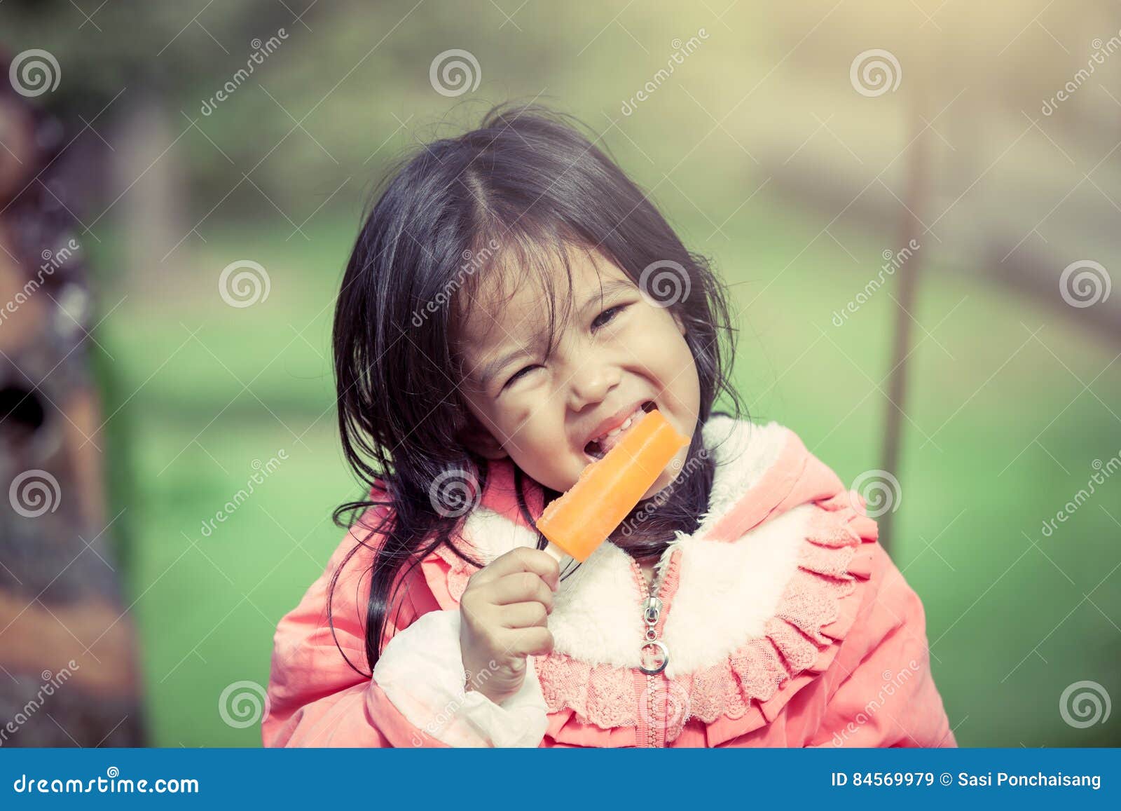 Cute Asian Little Girl Is Eating Icecream In The Park Stock Image