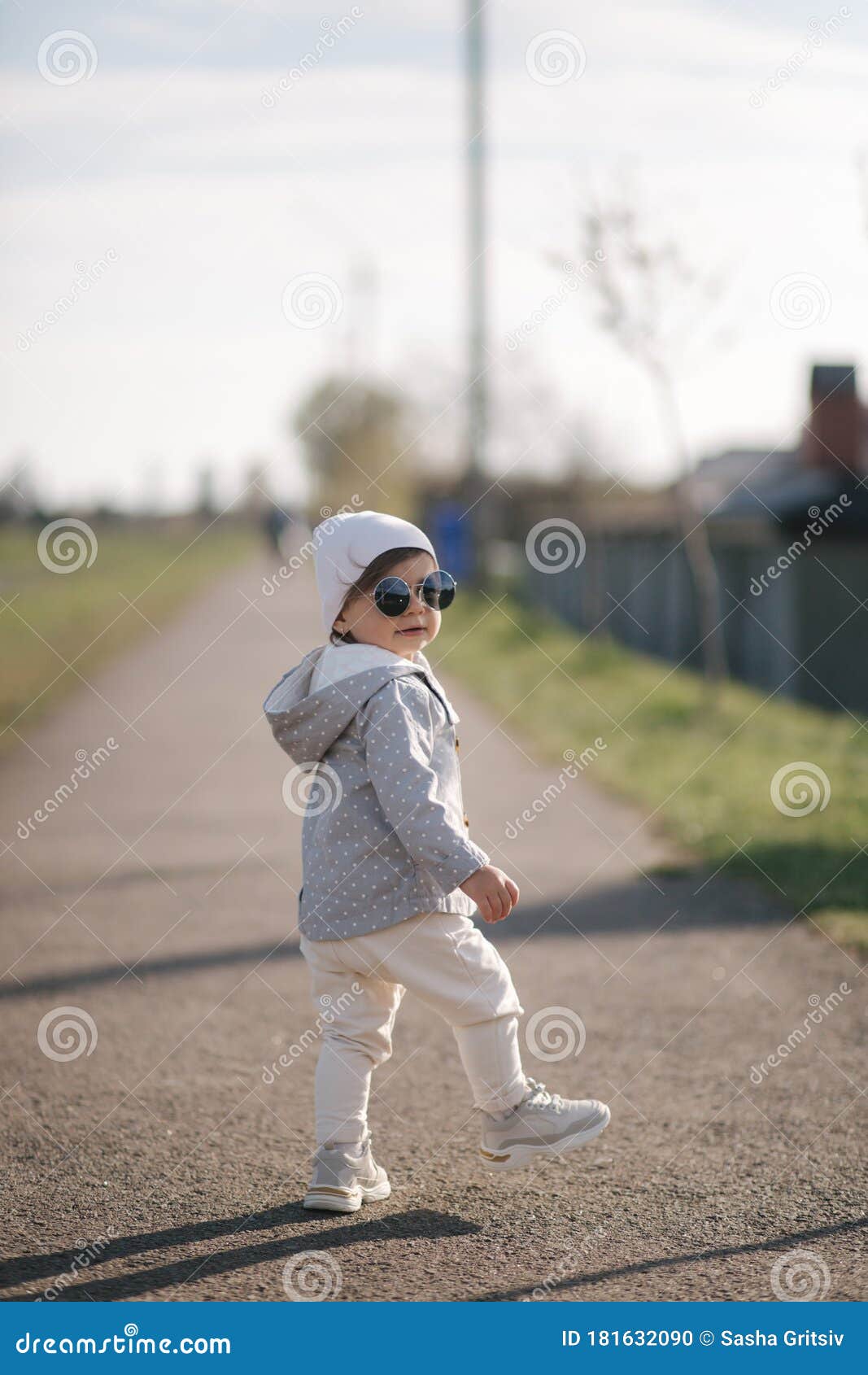 Cute Baby Girl Walking in the Park Near the Embankment. Stylish ...