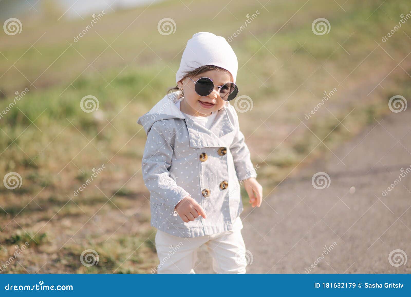 Cute Baby Girl Walking in the Park Near the Embankment. Stylish ...