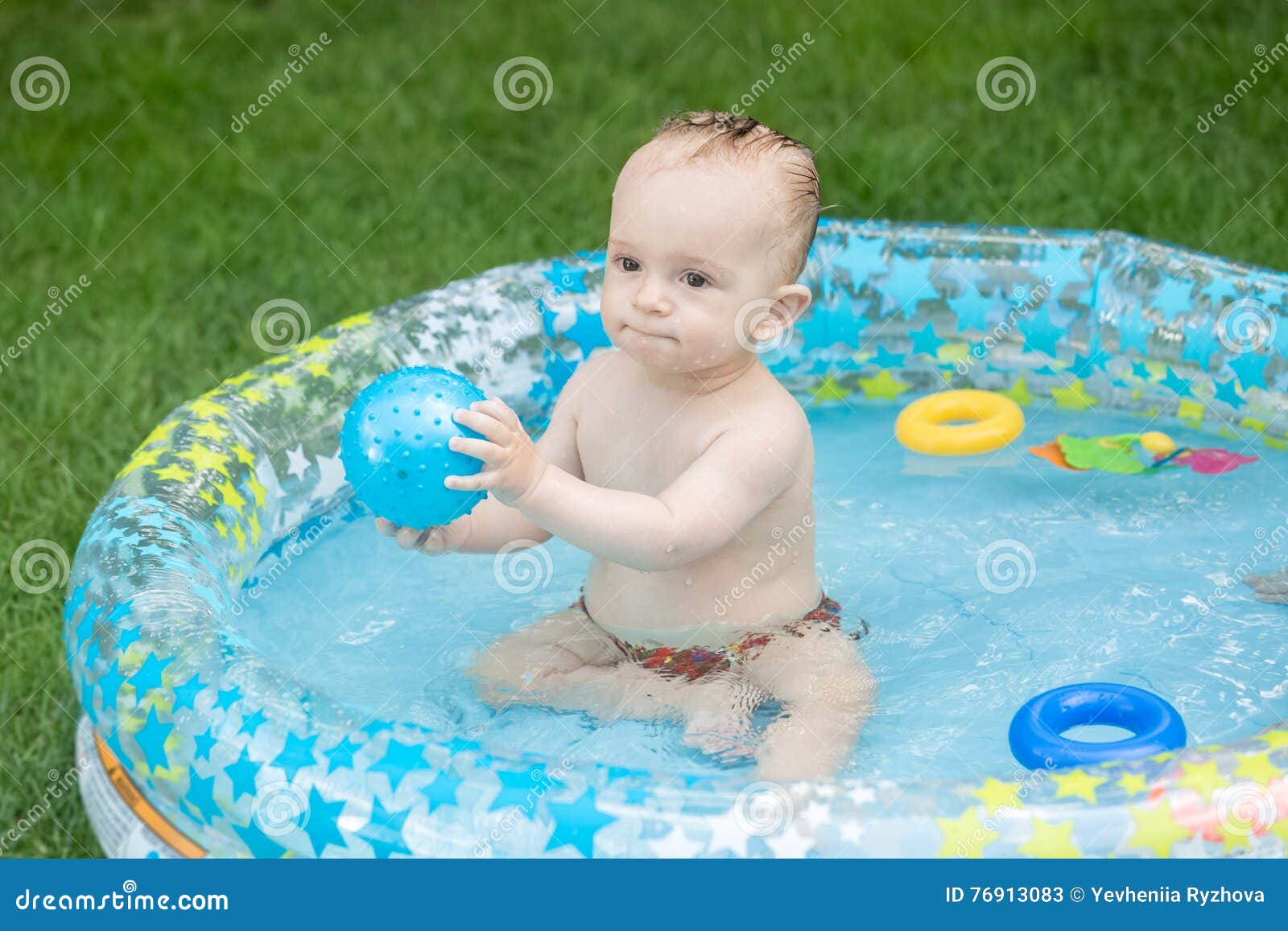Cute Baby Playing with Boy in the Swimming at Backyard Stock Image