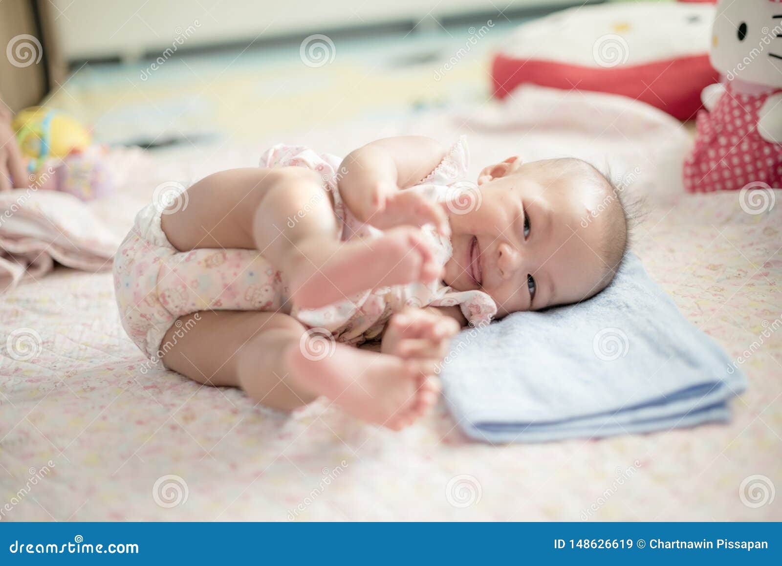 Cute Baby `s rolling time with smile. Baby is playing on bed. Baby is laughing