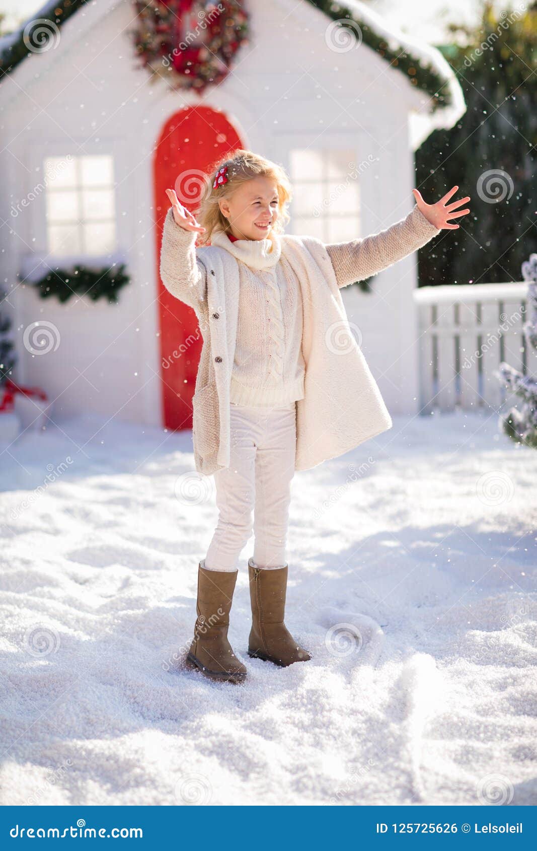 Cute Blonde Girl Playing With Snow Near The Small House And Snow