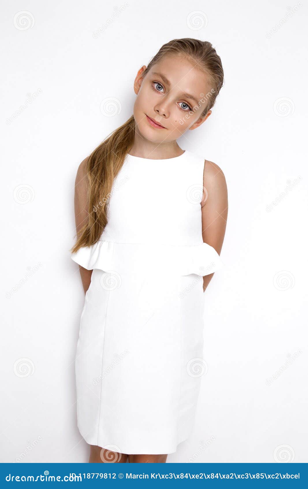 Cute Blonde Little Girl in a White Elegant Dress, Standing on a White ...