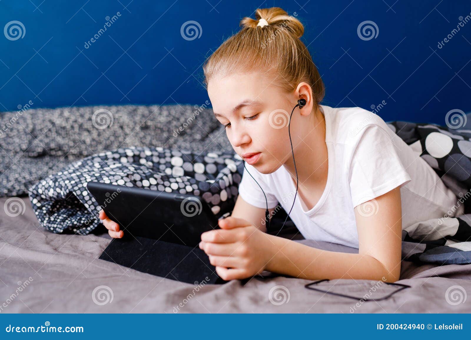 Cute Blonde Teen Girl Watching Video on Smartphone on the Bed, Child ...