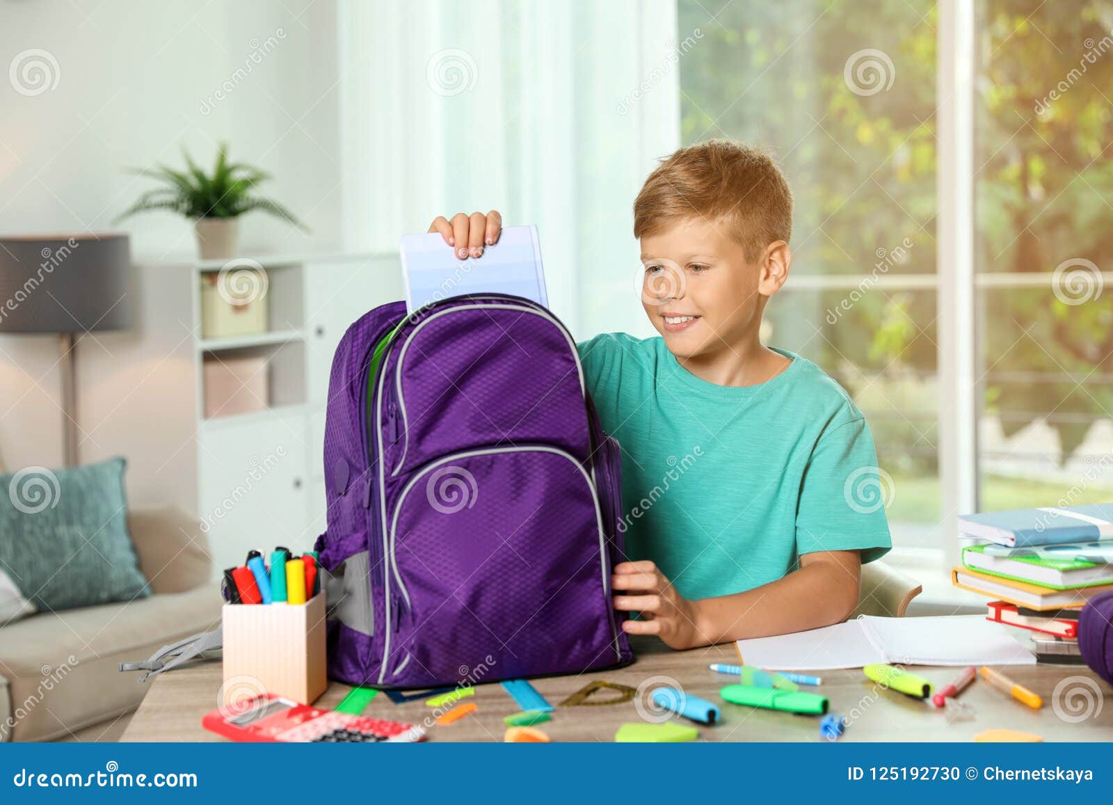 Сложив в портфель. Мальчик собирается в школу. Ребенок собирает портфель в школу. Мальчик собирает портфель в школу. Ребенок собирает рюкзак.