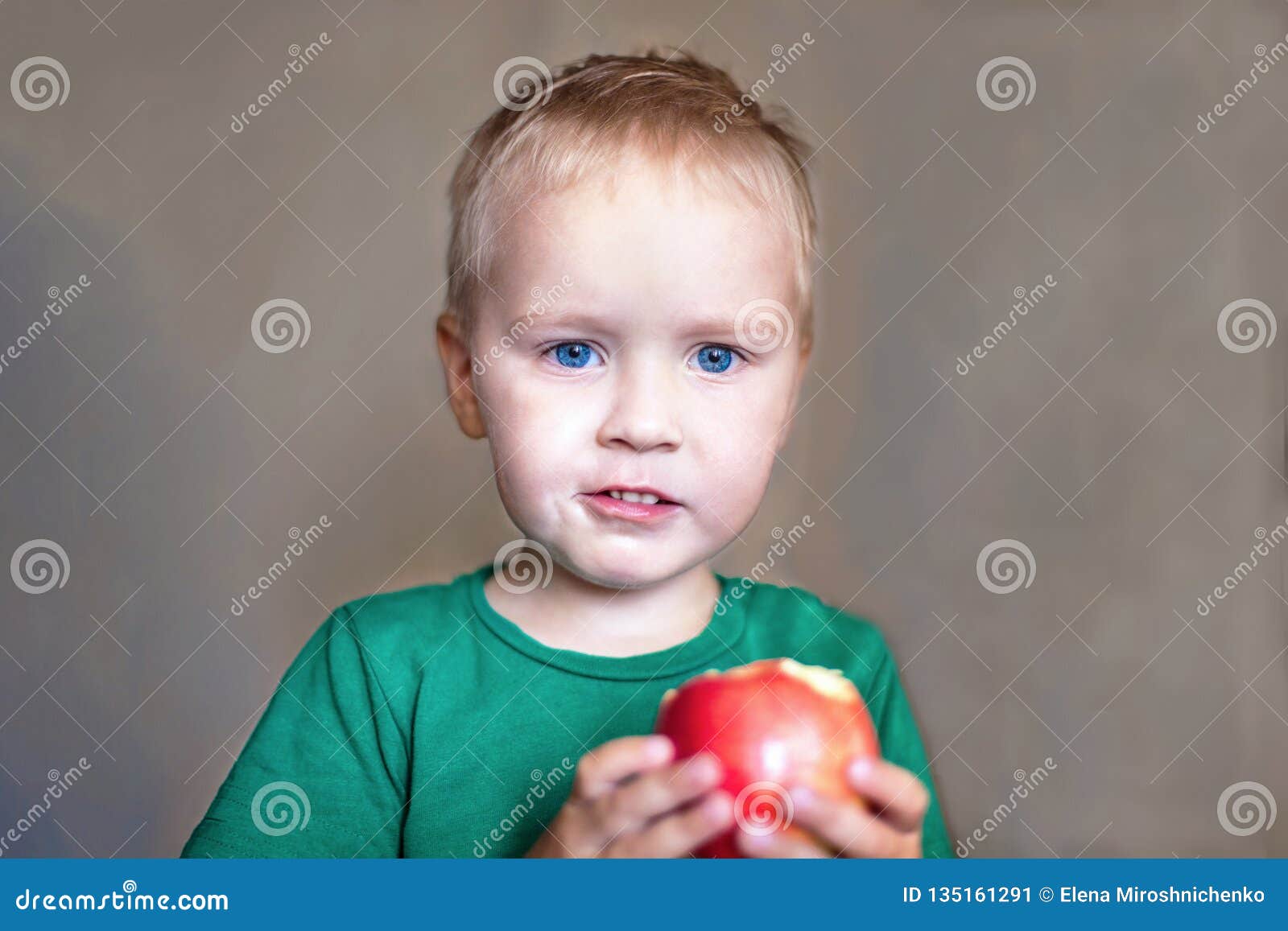 Cute Caucasian Baby Boy With Blue Eyes And Blonde Hair In Green T