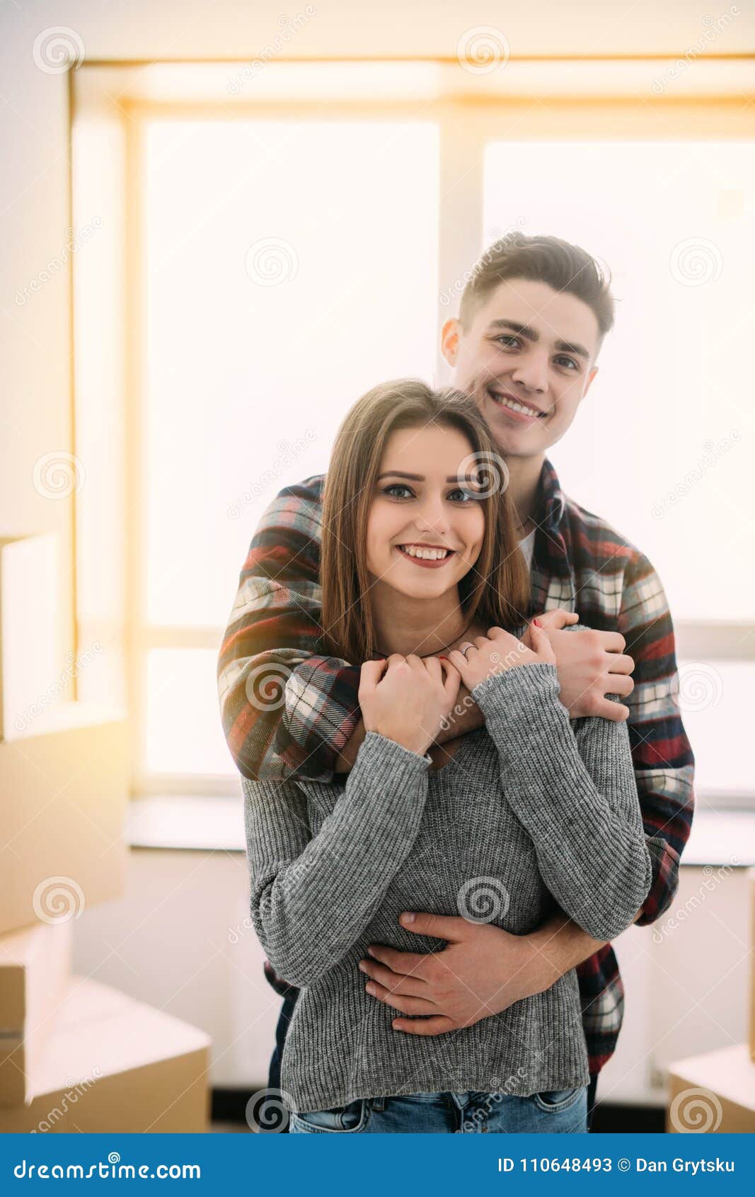 Cute Couple Hugging and Smiling in Their New Home. Moving To New ...