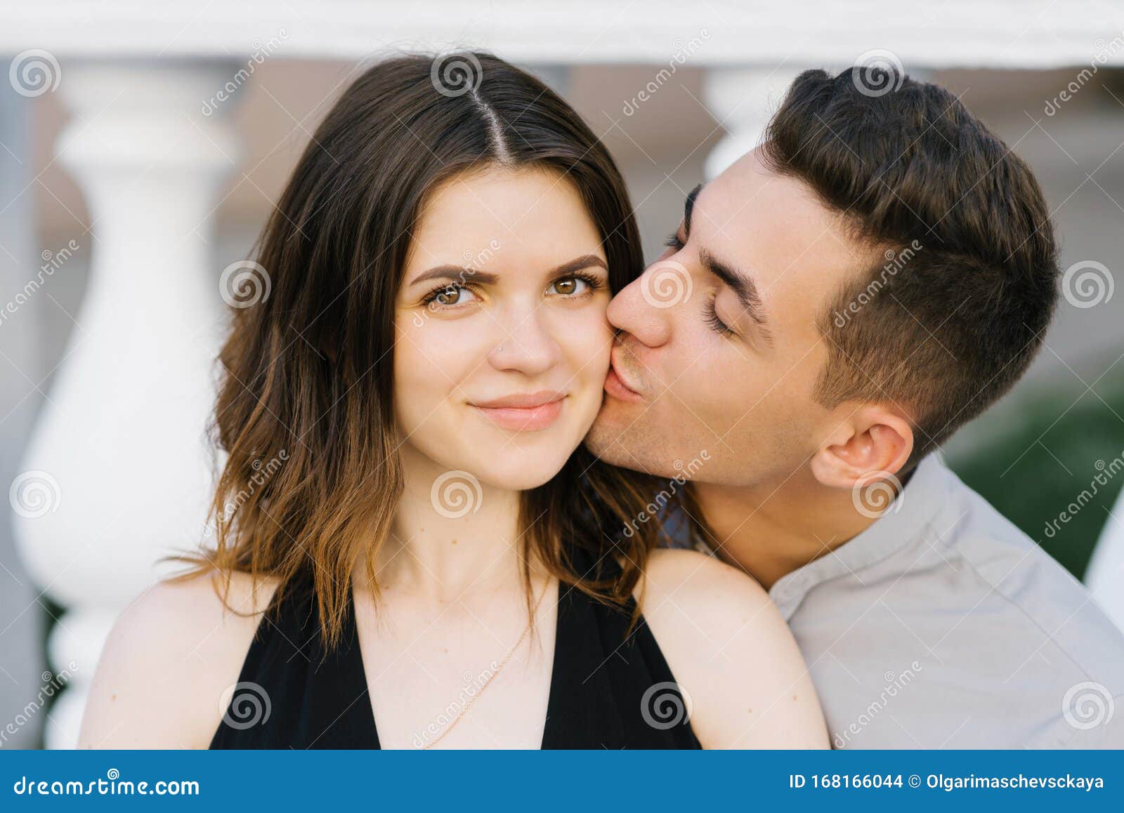 Cute Couple in Love Posing on the Street. a Young Man Kisses a ...