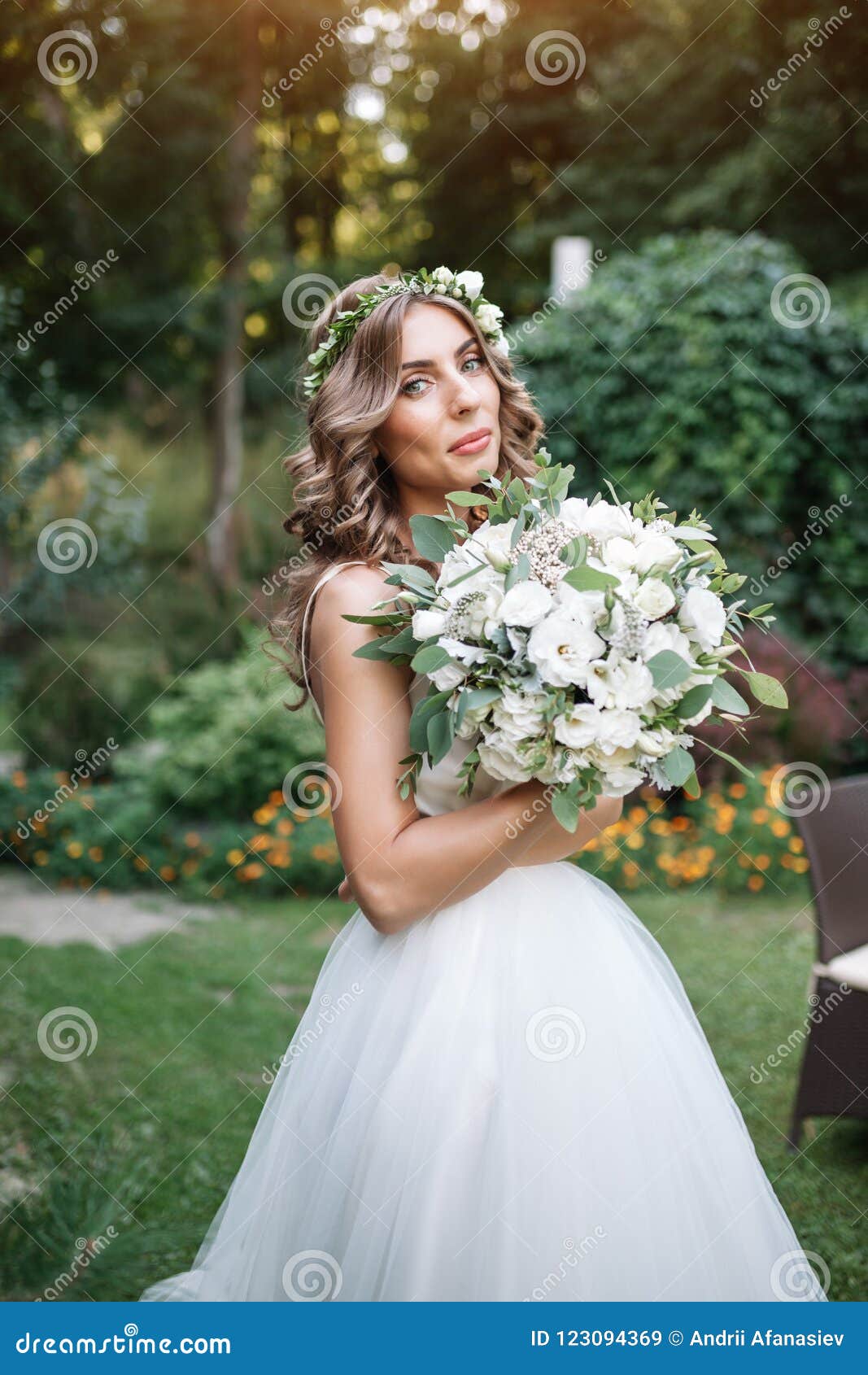 A Cute Curly Woman In A White Wedding Dress With A Wedding