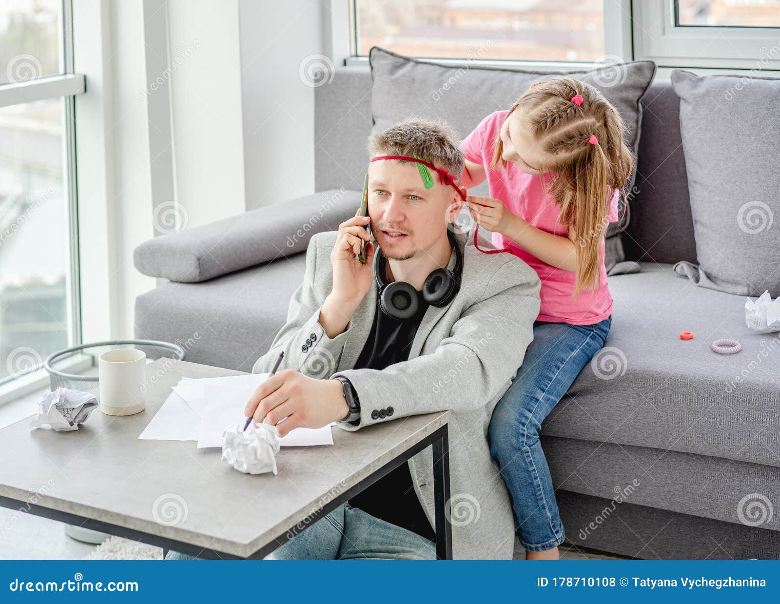 cute daughter decorating teleworking father